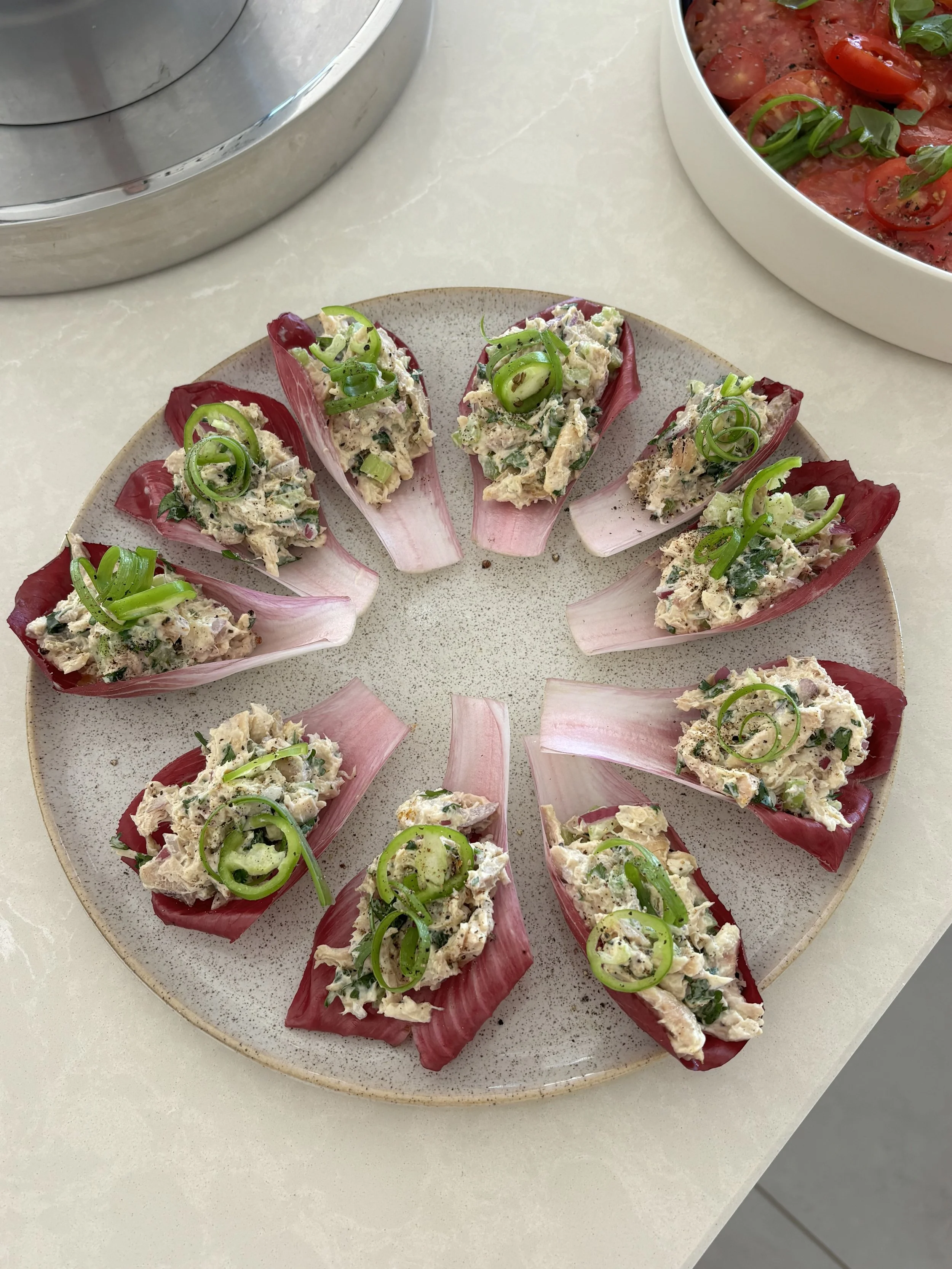 Coronation Chicken Chicory Boats  Coronation chicken layered in crisp chicory leaves with fresh herbs, citrus, and finished with scallion curls.