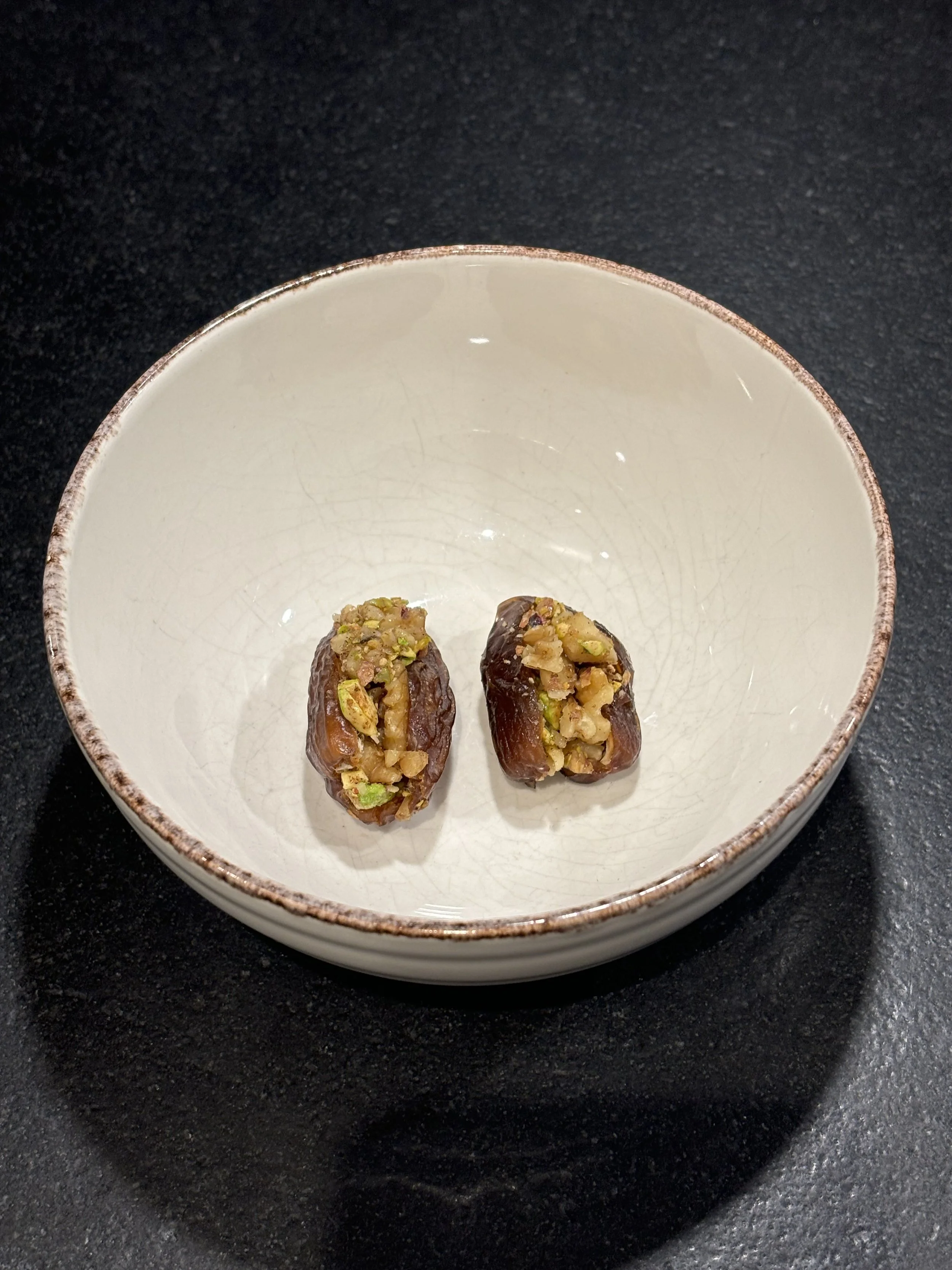 Organic Dark Chocolate and Pistachio Stuffed Dates.  Medjool dates filled with organic dark chocolate and pistachios, finished with spiced walnuts and natural date caramel.