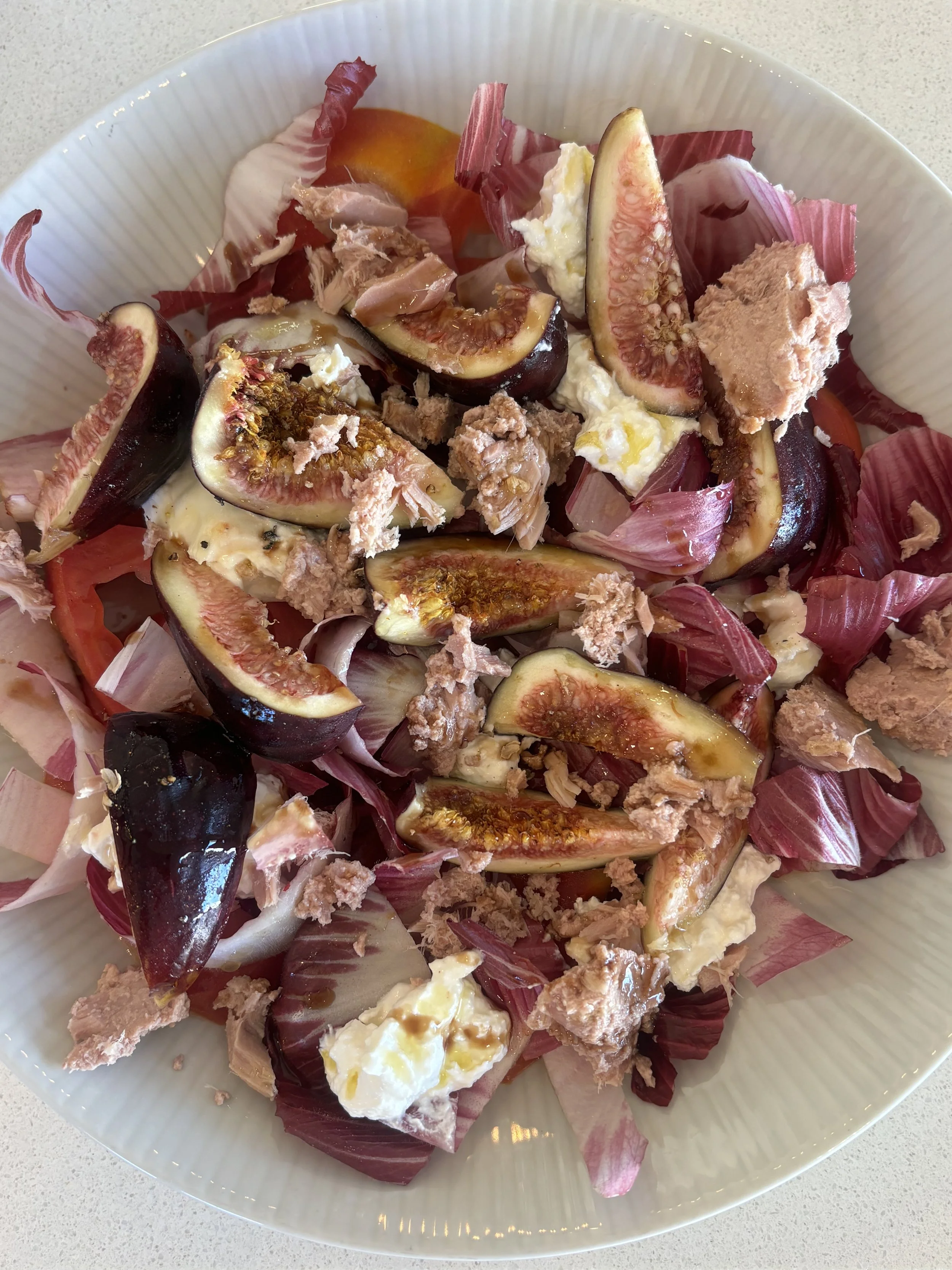 Fig, Tuna, and Burrata Salad  Fresh figs and radicchio tossed with line-caught tuna, burrata, heirloom tomatoes, and aged balsamic vinaigrette.