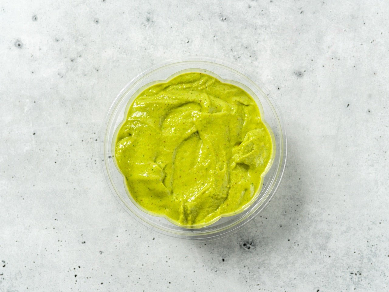  The bowl contains a vibrant green smoothie mix. 