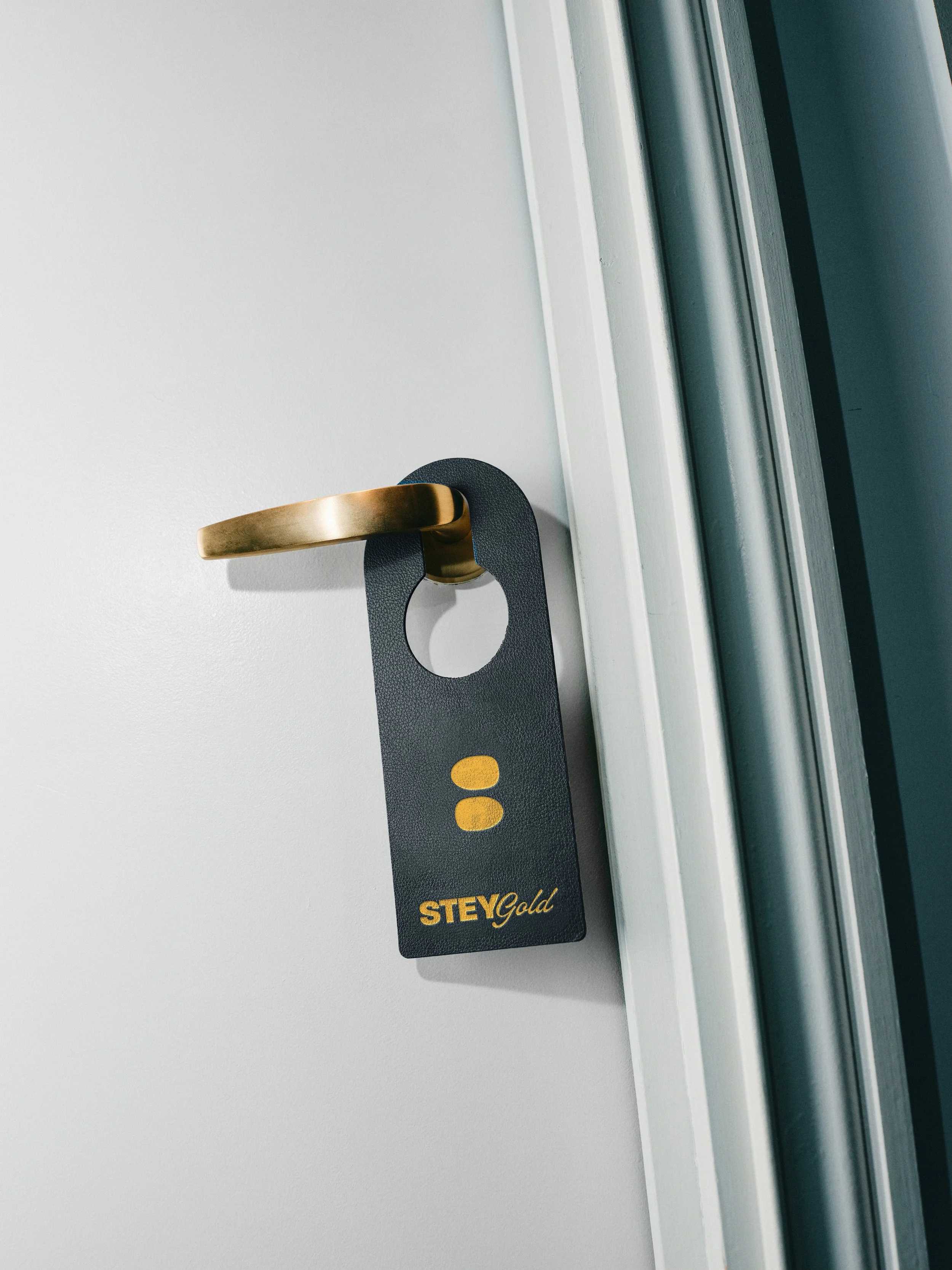 Stey Gold branded tag on door handle featuring black and gold design representing luxury nail brand
