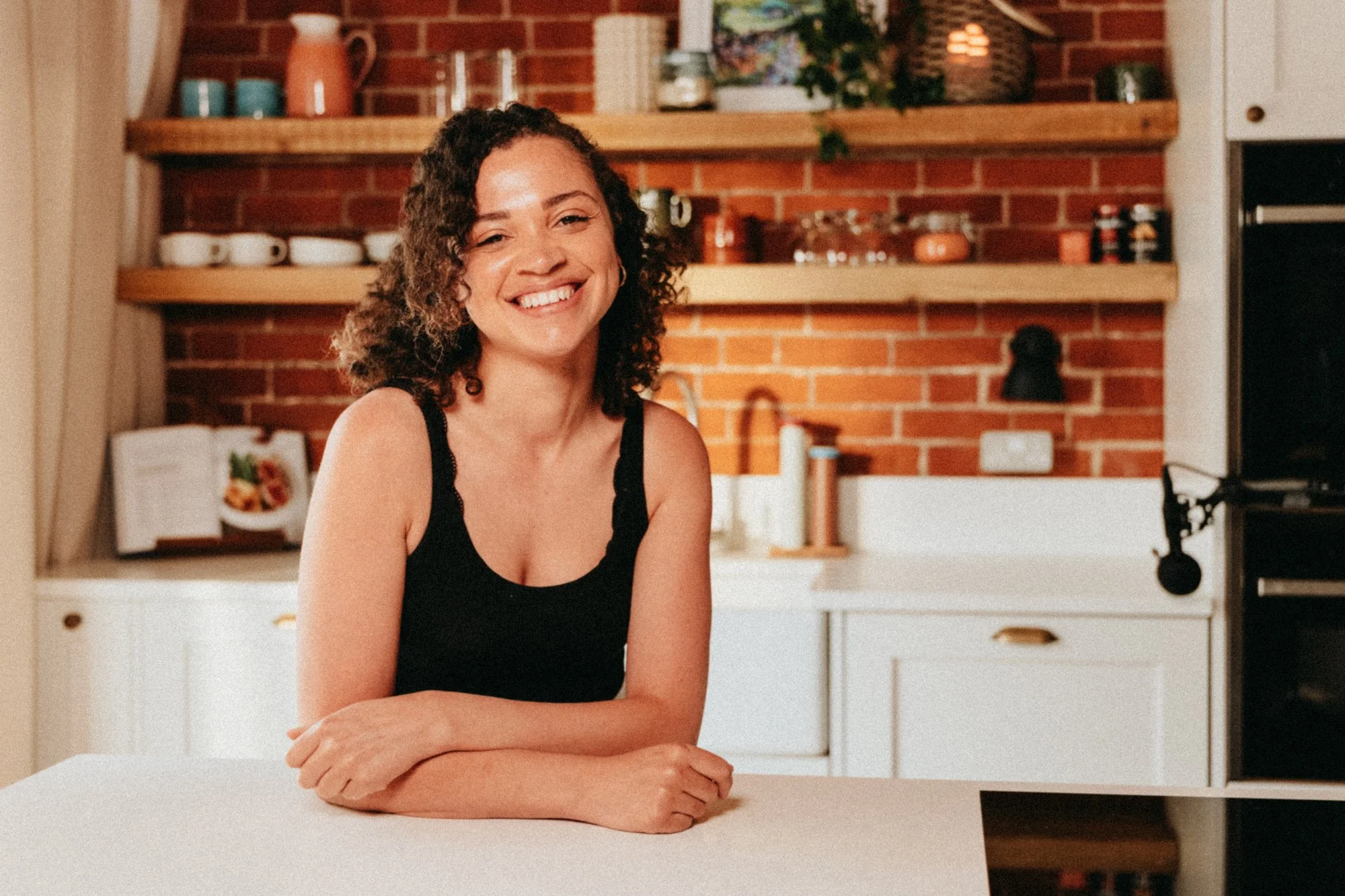 Woman with a pretty hijab smiling in a modern kitchen.