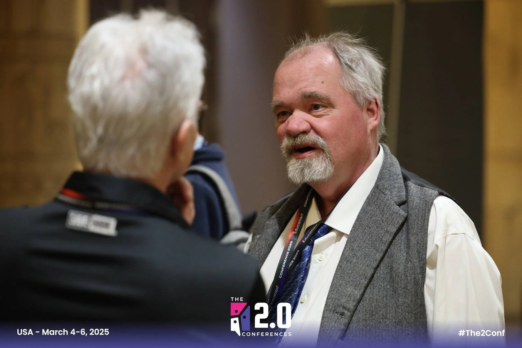 Hitchcock speaks with another panelist in Las Vegas