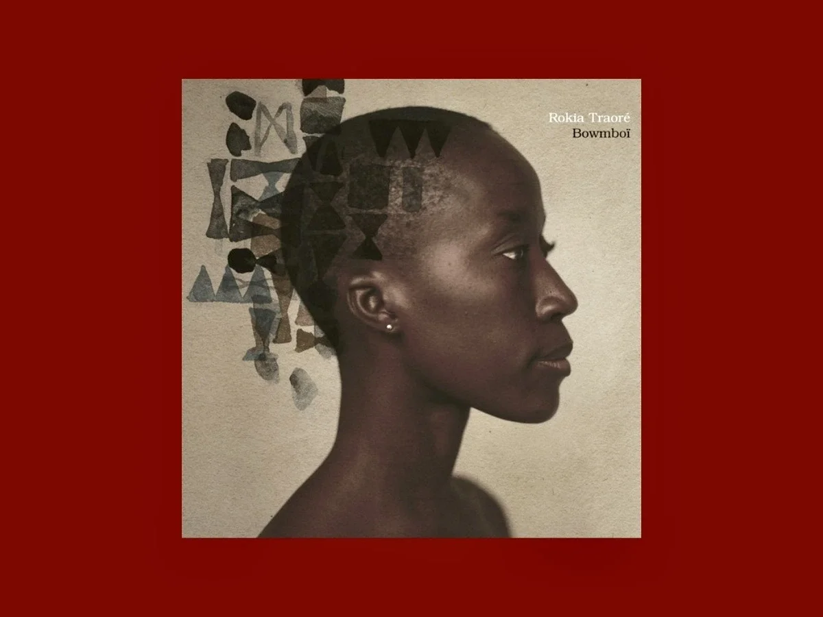 Album cover for Rokia Traoré’s Bowmboi featuring a side-profile portrait against a deep red background, reflecting intimate Malian folk music.