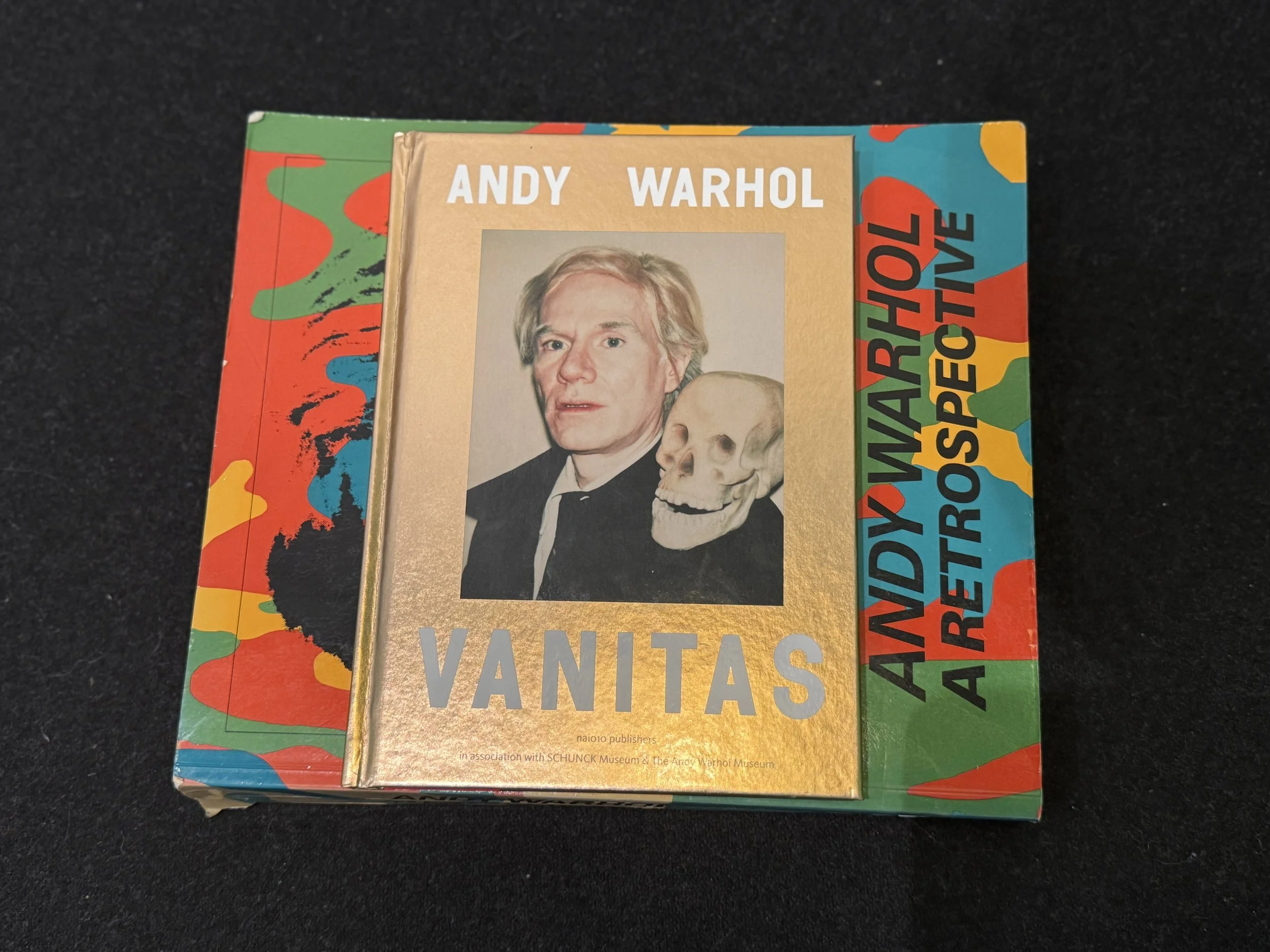 Andy Warhol art books featuring a gold-cover portrait and bright retro design, highlighting Warhol’s influence on modern pop art and culture.