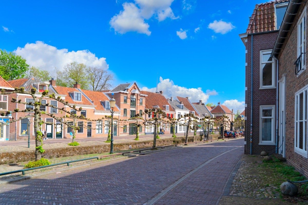 Traditional Dutch houses along a cobblestone street in the Netherlands, reflecting the post-war historical fiction setting of The Safekeep.