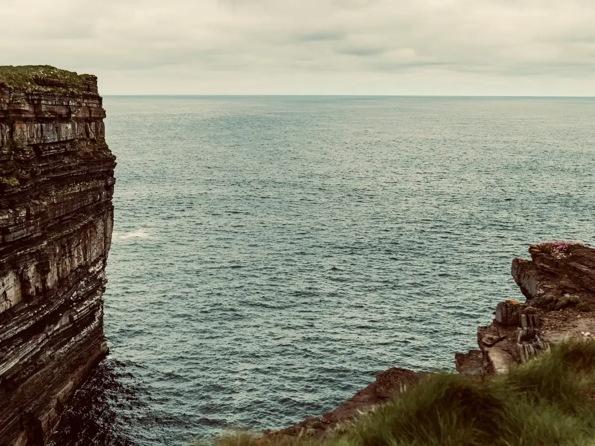 Rugged sea cliffs overlooking the Atlantic Ocean, evoking the coastal landscape associated with The Pirate Queen by Ariel Lawhon.