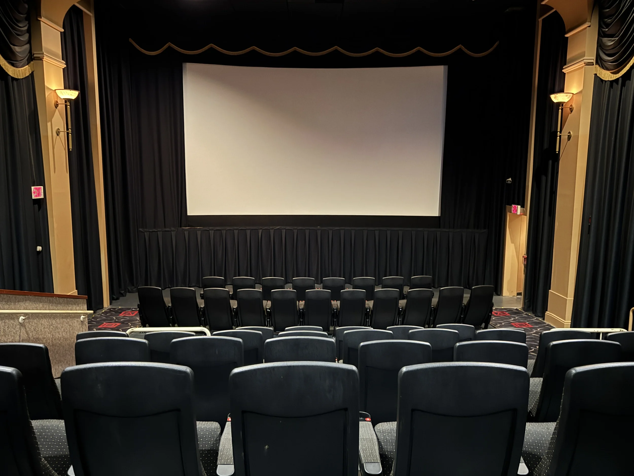 Empty red cinema seats facing a blank screen in a dark movie theater, symbolizing a story waiting to meet its audience