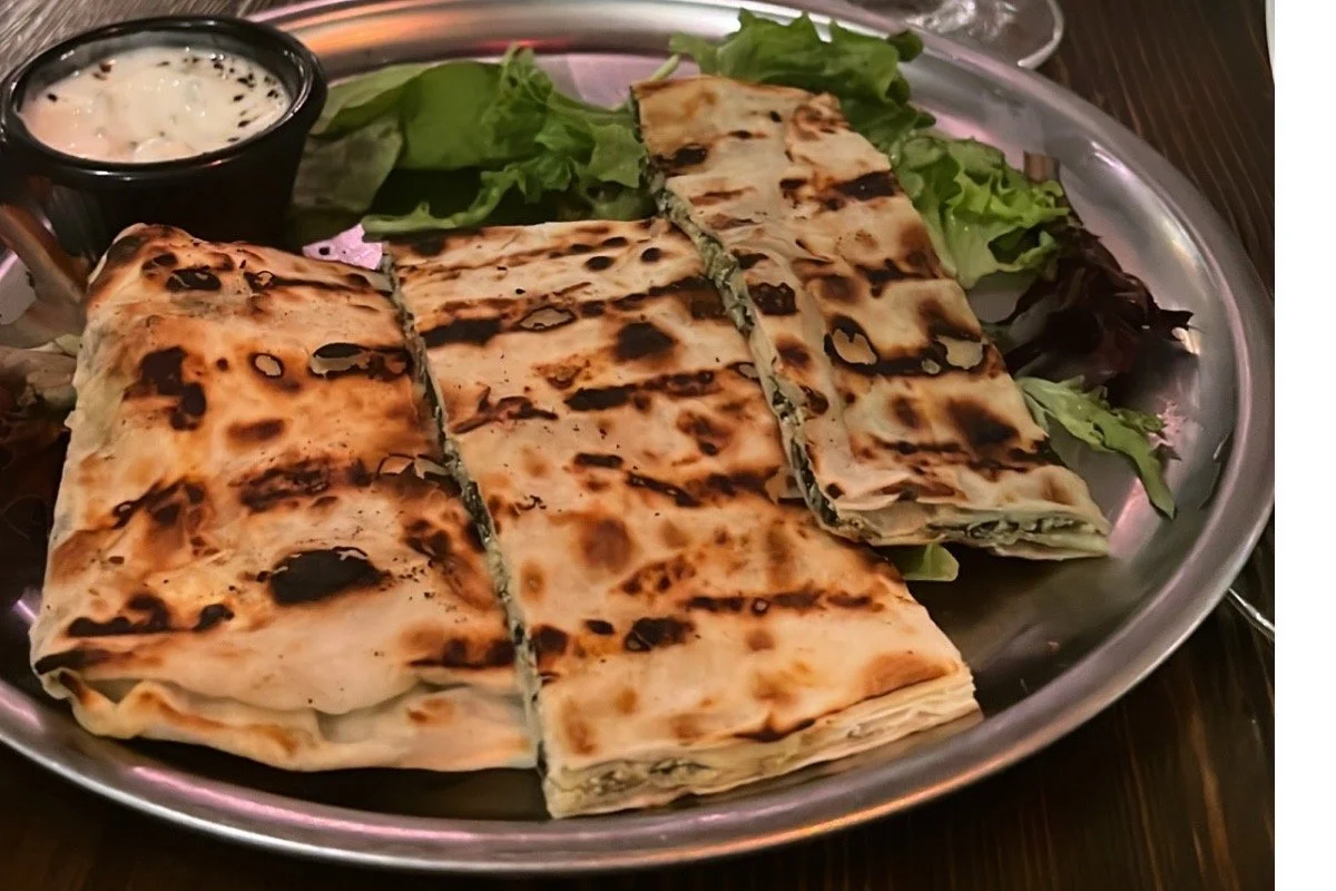 Traditional Persian flatbread on a ceramic plate, representing Iranian food as cultural memory and domestic storytelling in The Lion Women of Tehran.