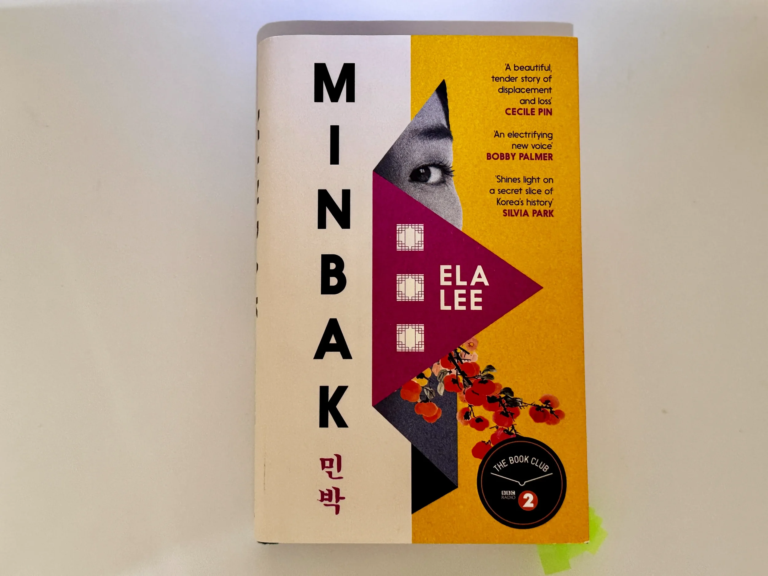 Minbak by Ela Lee — geometric cover design with half-face and Korean typography, paired with a han-inspired literary playlist