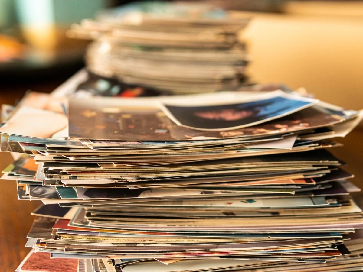 Stack of personal photographs with the top image in focus and the rest blurred, representing selective memory