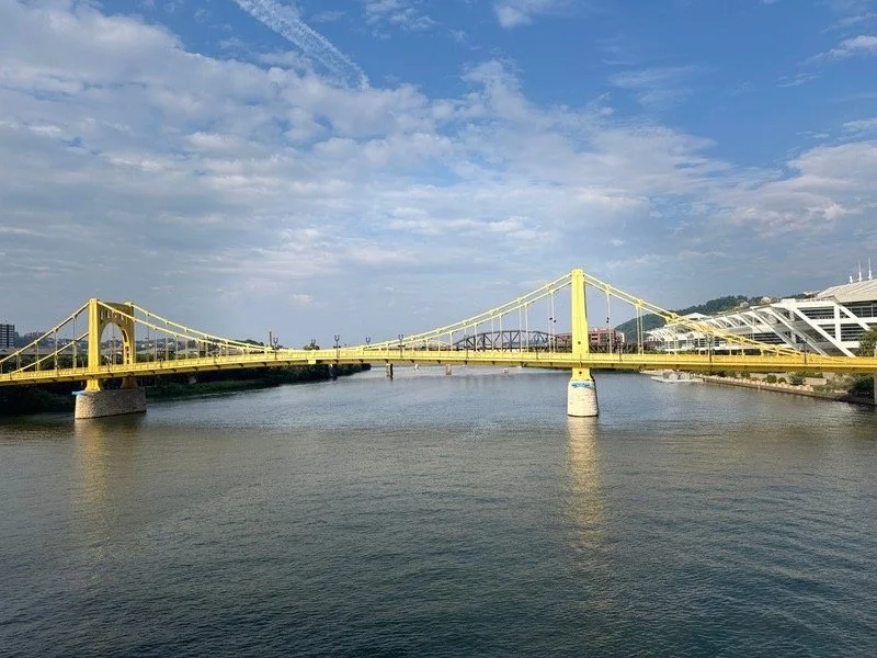 Roberto Clemente Bridge spanning the Allegheny River in Pittsburgh, showcasing the city's iconic yellow bridges, riverfront views, and walkable downtown skyline