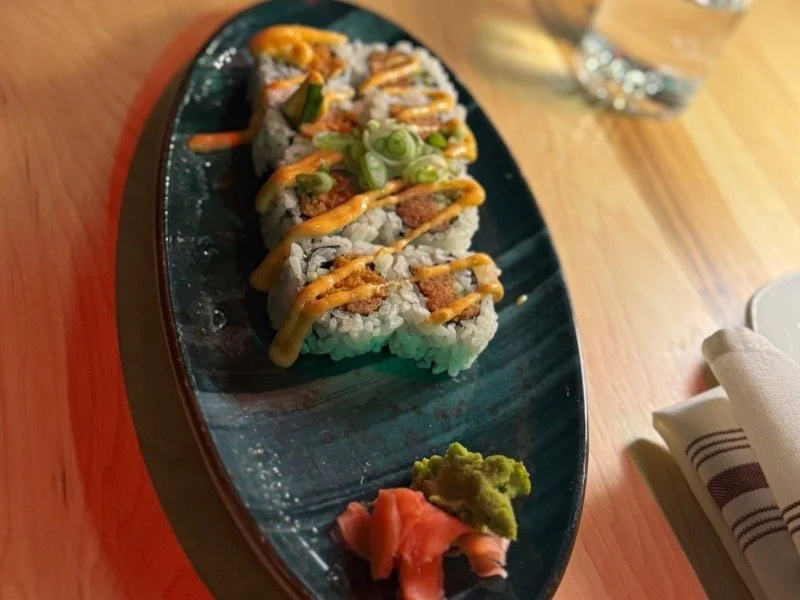 Plated sushi rolls with spicy sauce, wasabi, and pickled ginger at a Pittsburgh restaurant, showcasing the city’s diverse global cuisine and evolving culinary culture.