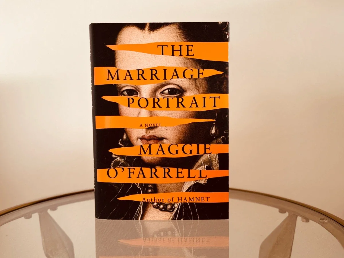 Book cover of The Marriage Portrait by Maggie O'Farrell — a Renaissance-era portrait of a young woman's face, partially obscured by horizontal orange strips bearing the title and author's name, with "Author of Hamnet" printed at the bottom.