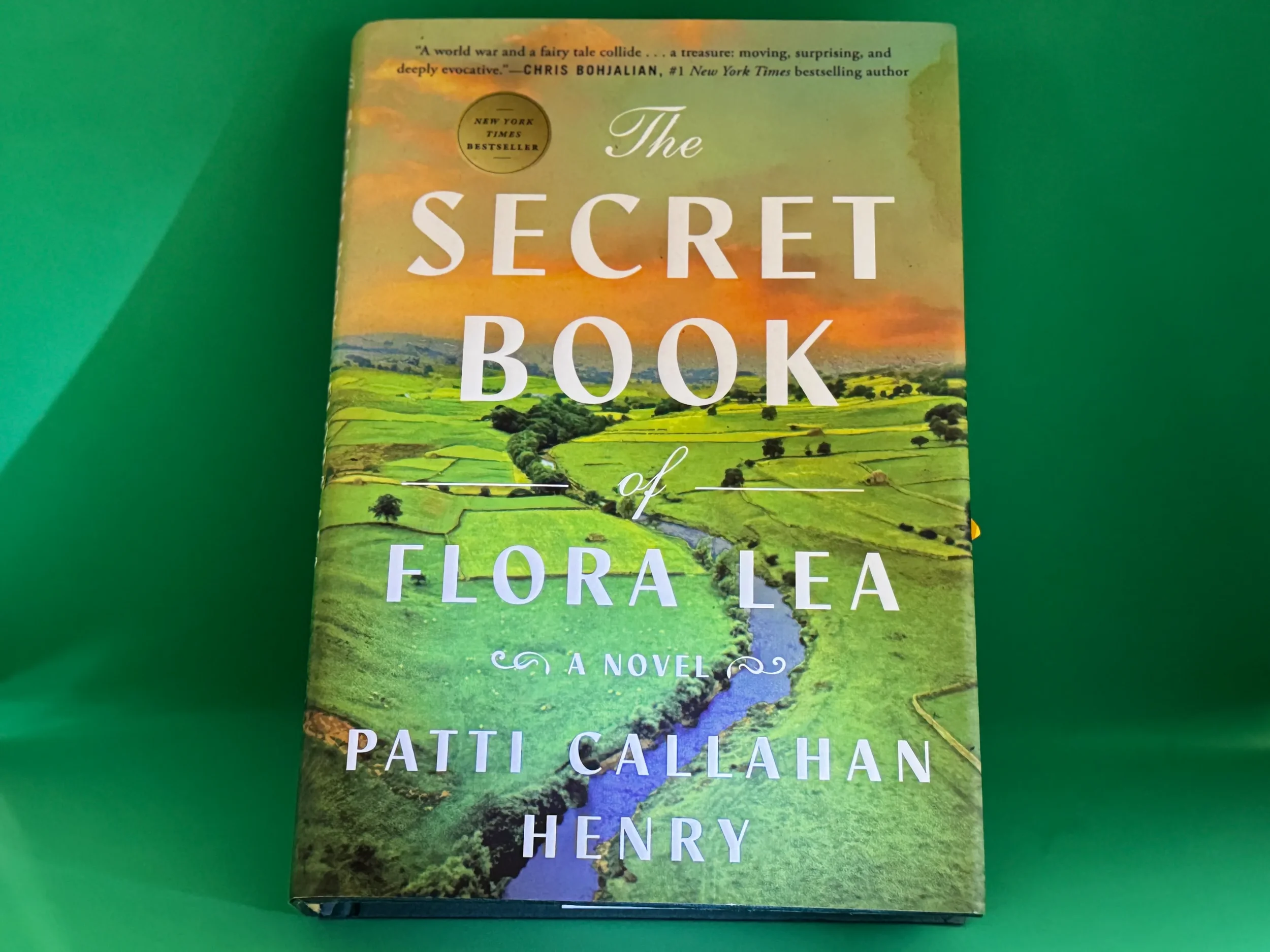 The Secret Book of Flora Lea by Patti Callahan Henry — pastoral English countryside cover on green background, paired with a Vaughan Williams literary playlist