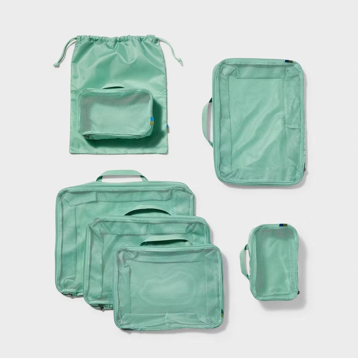 Open Story™ 7-piece compression packing cube set in sage green for organized travel and intentional packing.