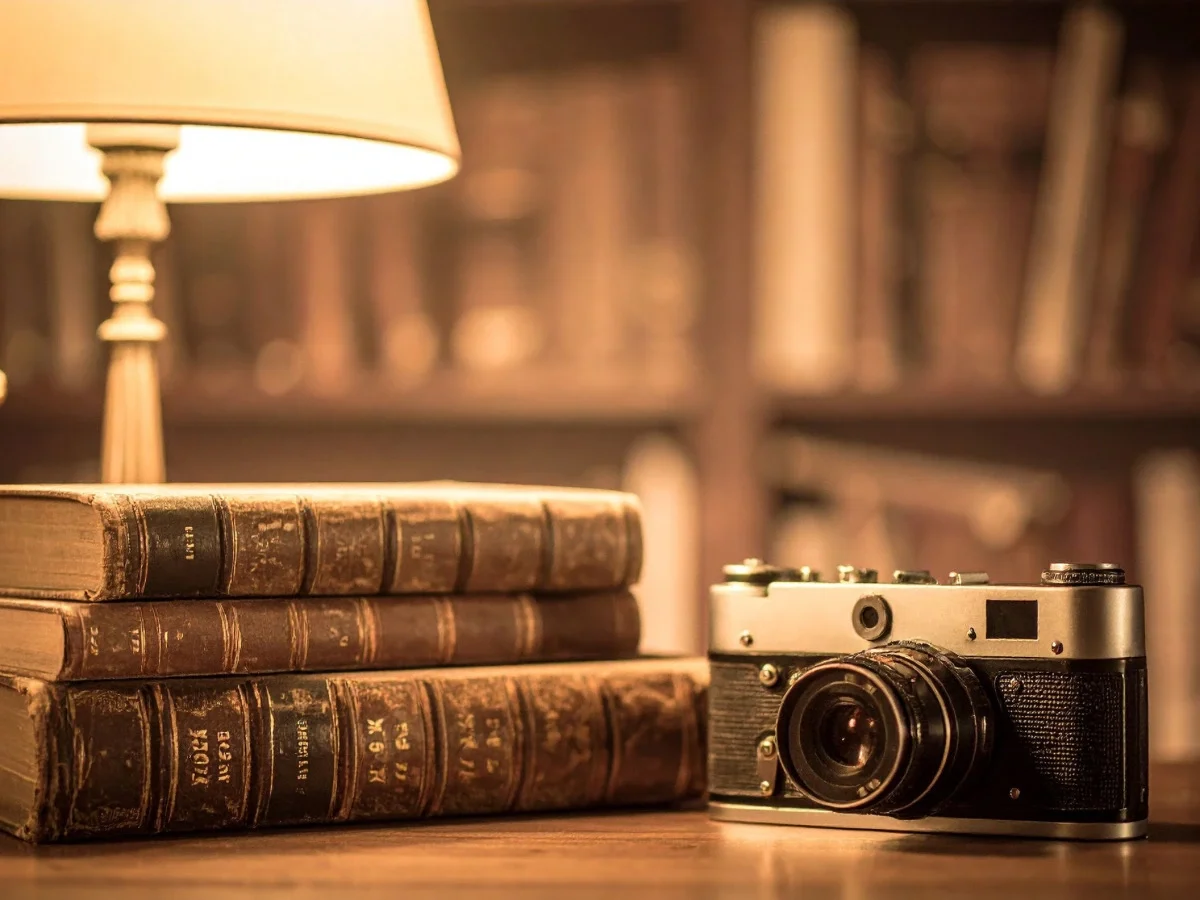 Vintage camera beside antique books, symbolizing the history of photography and how the camera changed the way we see.