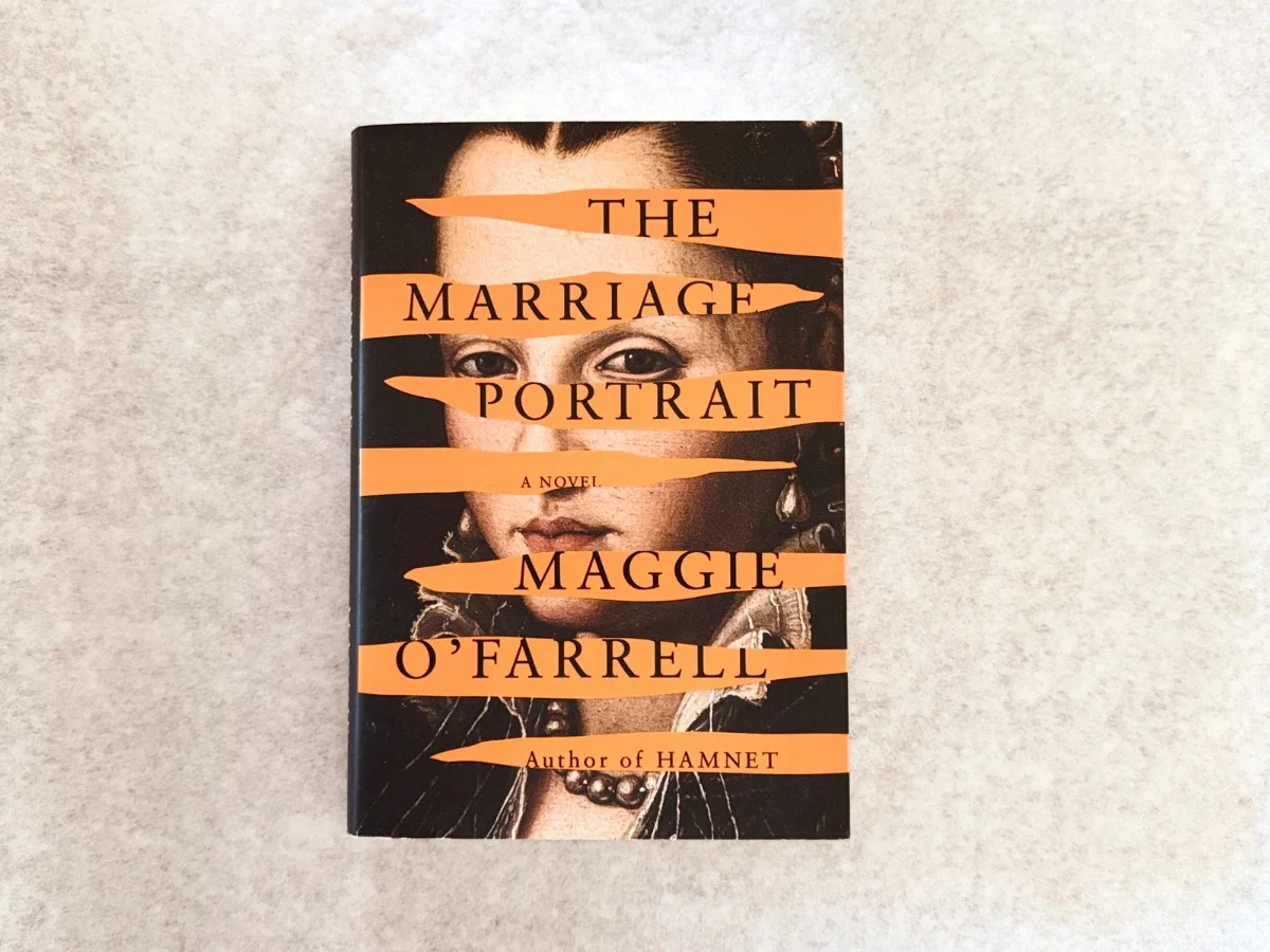 Book cover of The Marriage Portrait by Maggie O'Farrell — a Renaissance-era portrait of a young woman's face, partially obscured by horizontal orange stripes bearing the title The and author's name, with "Author of Hamnet" printed at the bottom.