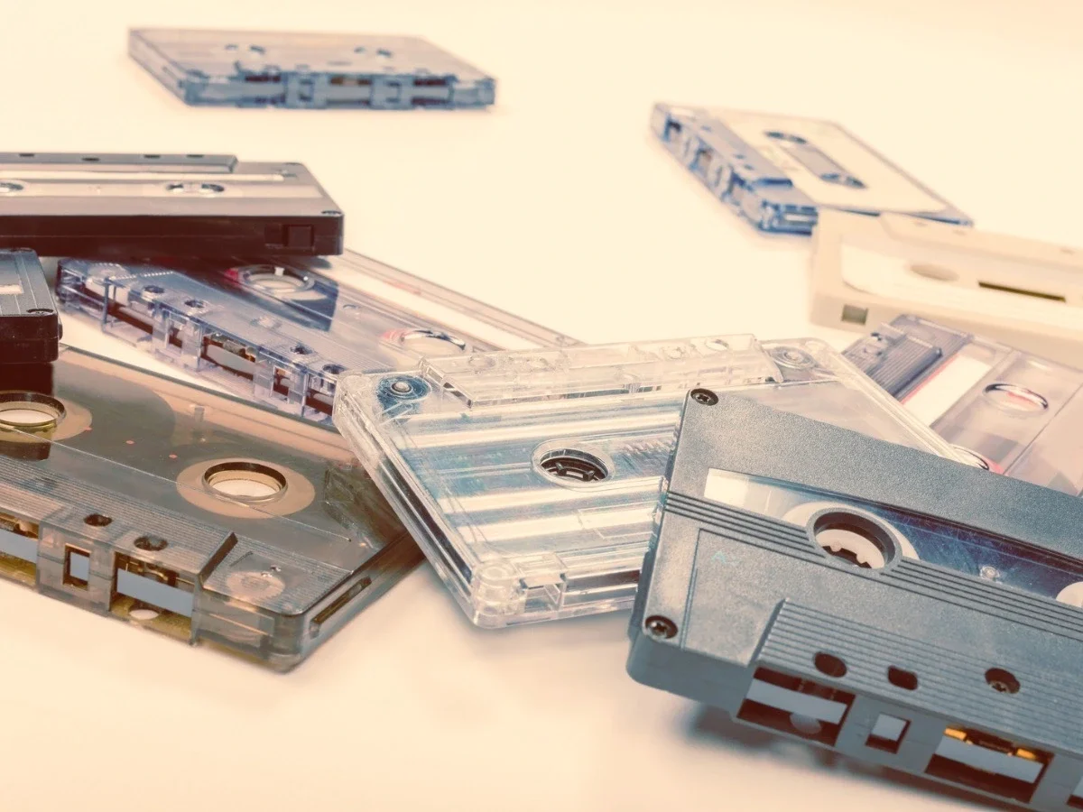 A collection of cassette tapes scattered across a light surface
