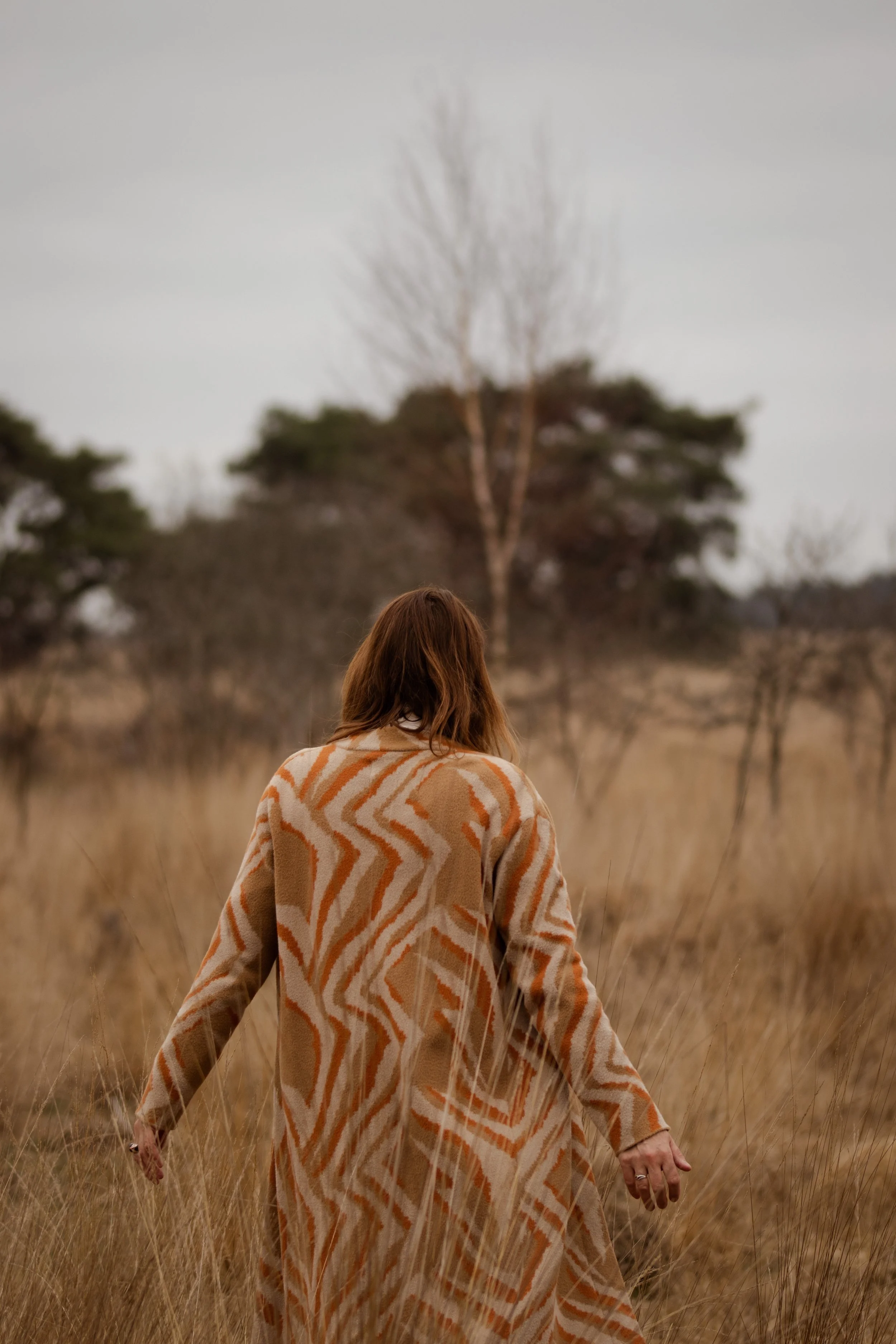 Trainer en coach wandelend in de natuur, van achteren gefotografeerd