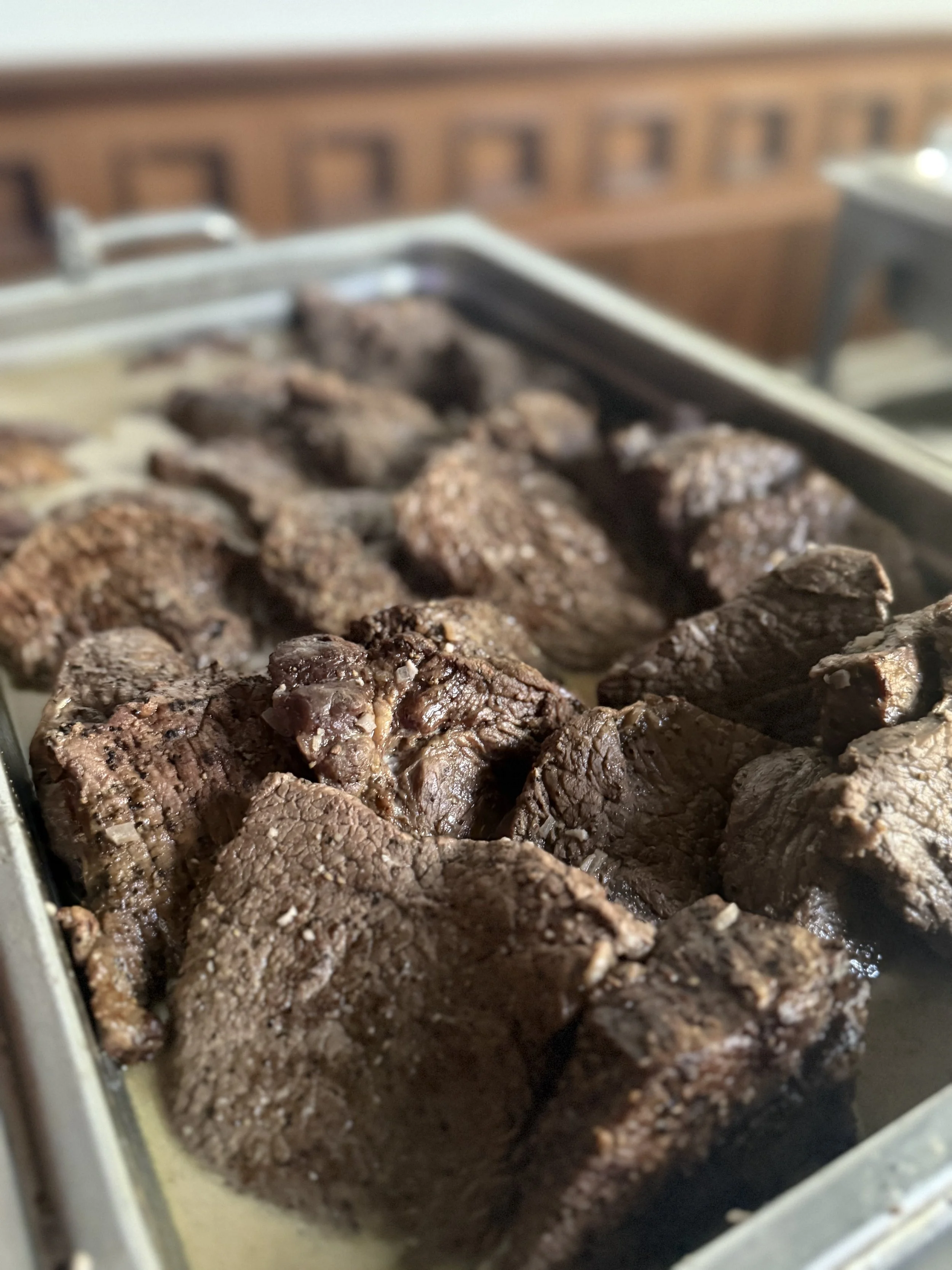 Chafing dish filled with cooked beef chunks.