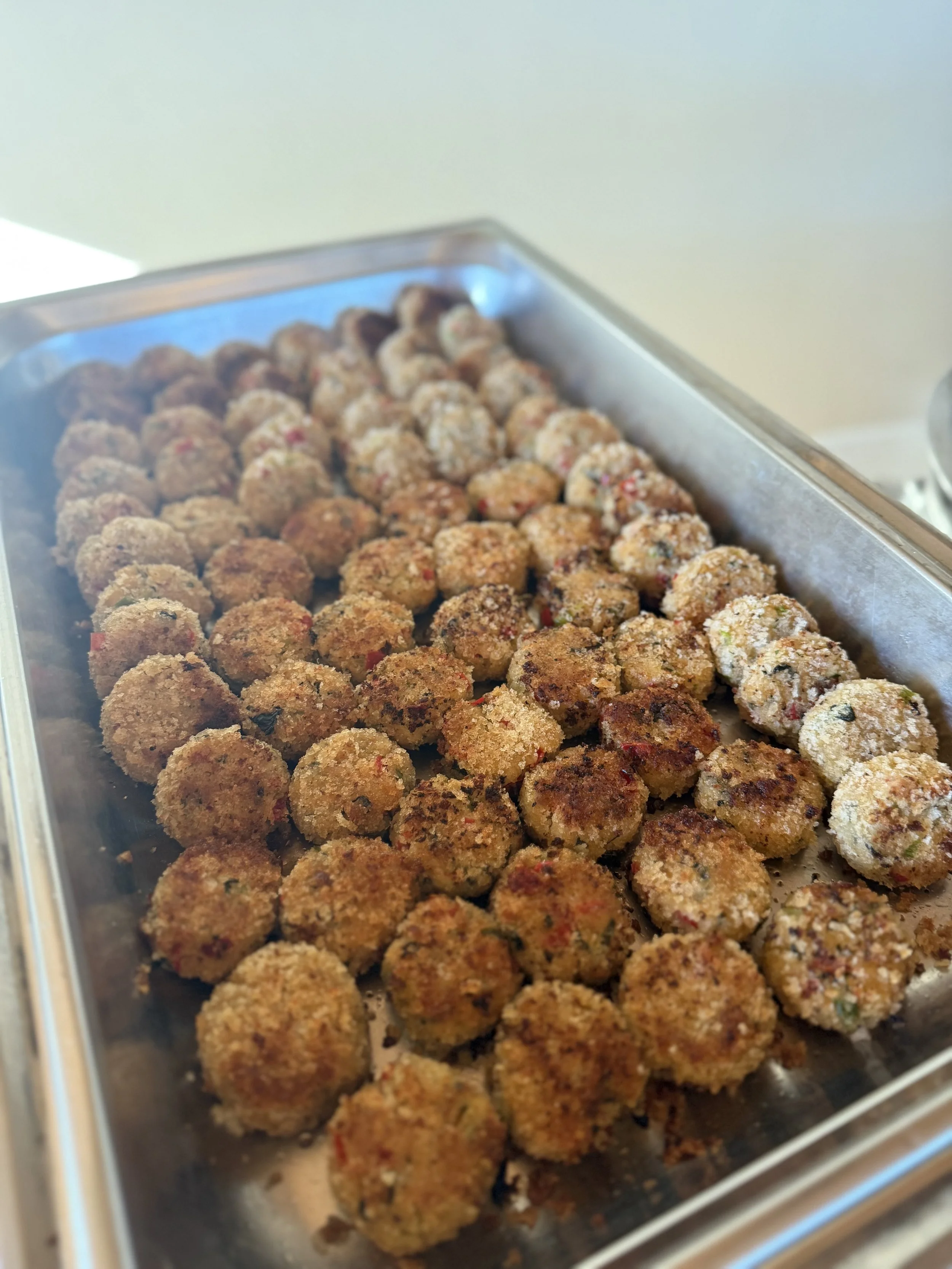 Tray of breaded, cooked meatballs.