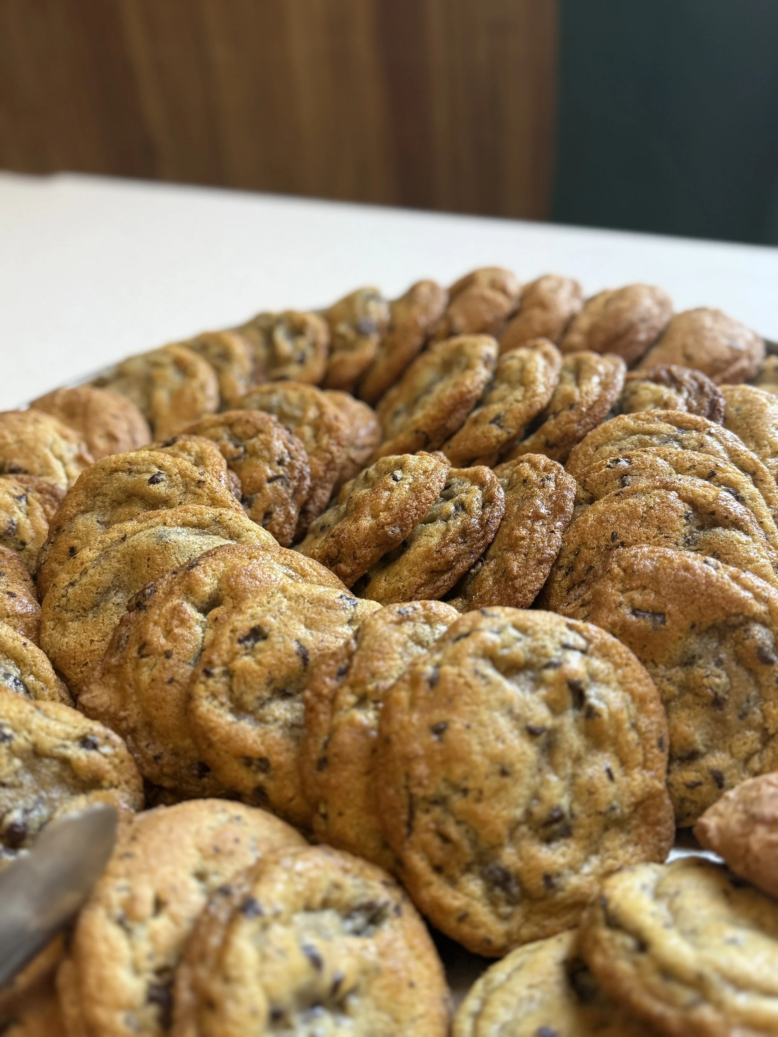 Close-up of a tray filled with freshly baked chocolate chip cookies.