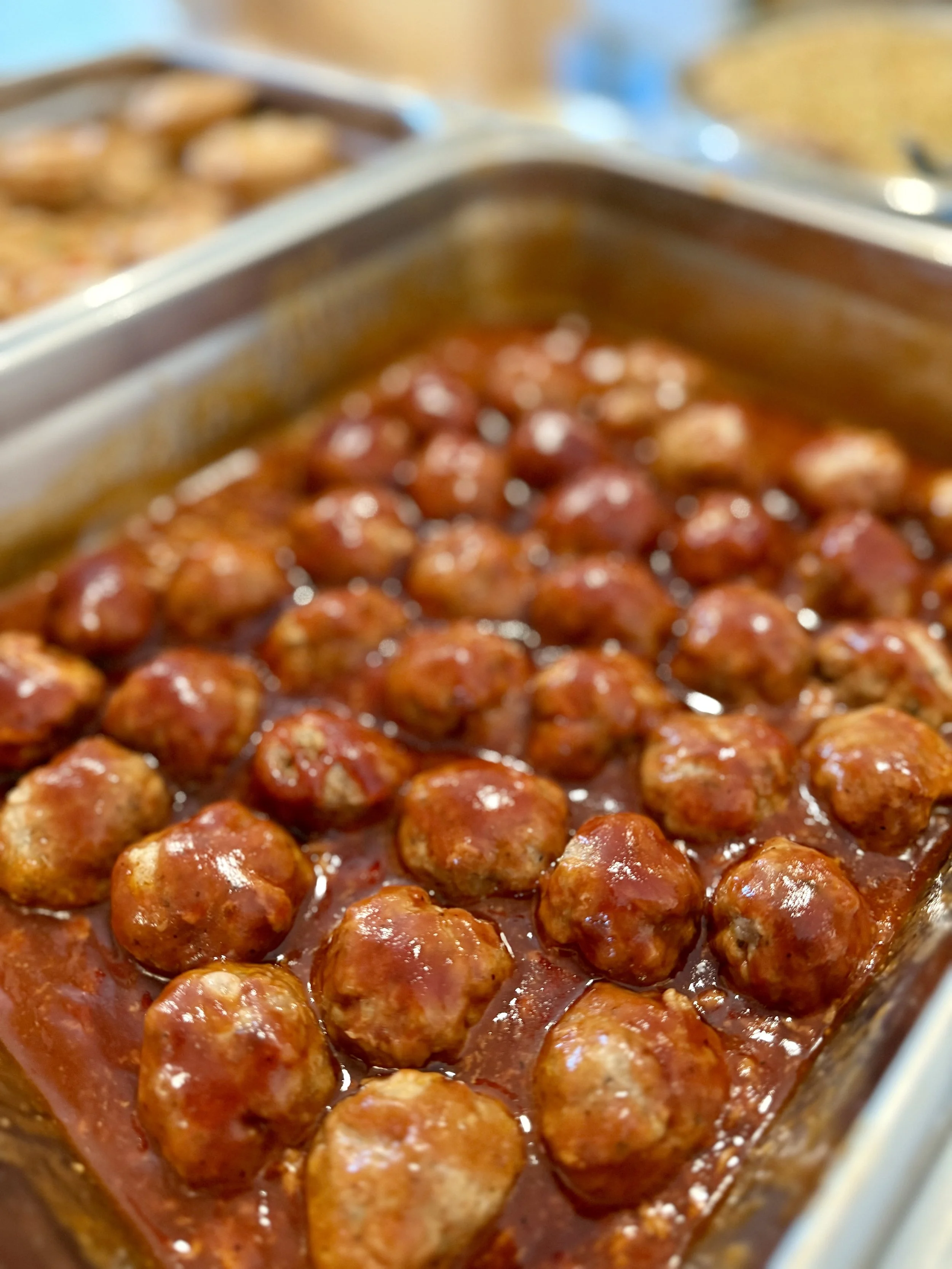 Tray of meatballs in marinara sauce.