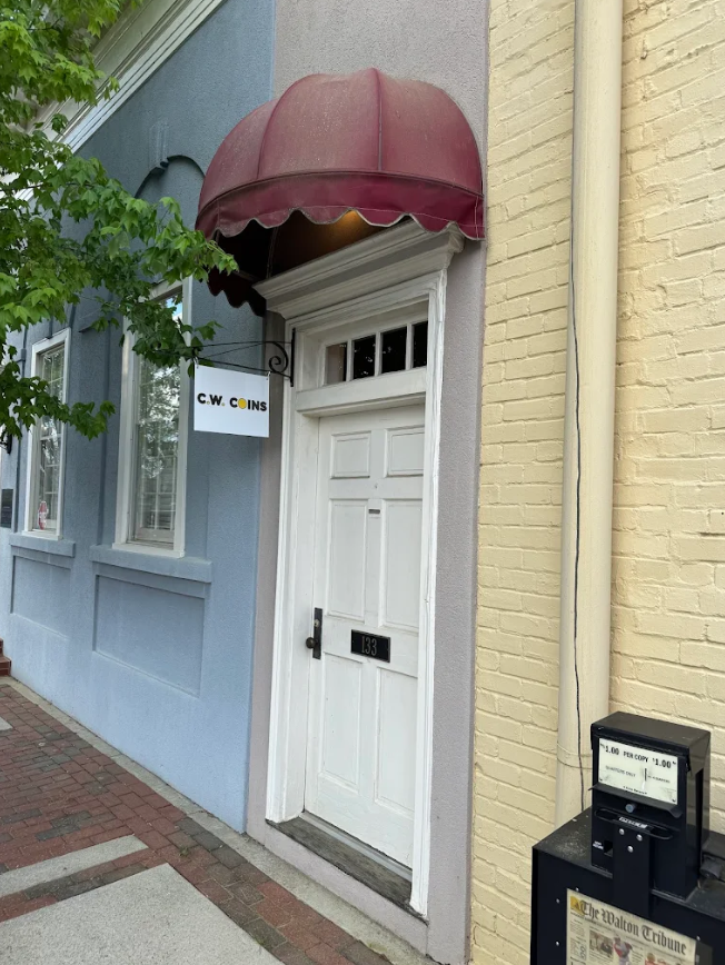 CW Coins storefront on E Hightower Trail in downtown Social Circle, Georgia — burgundy awning, white door at 133.