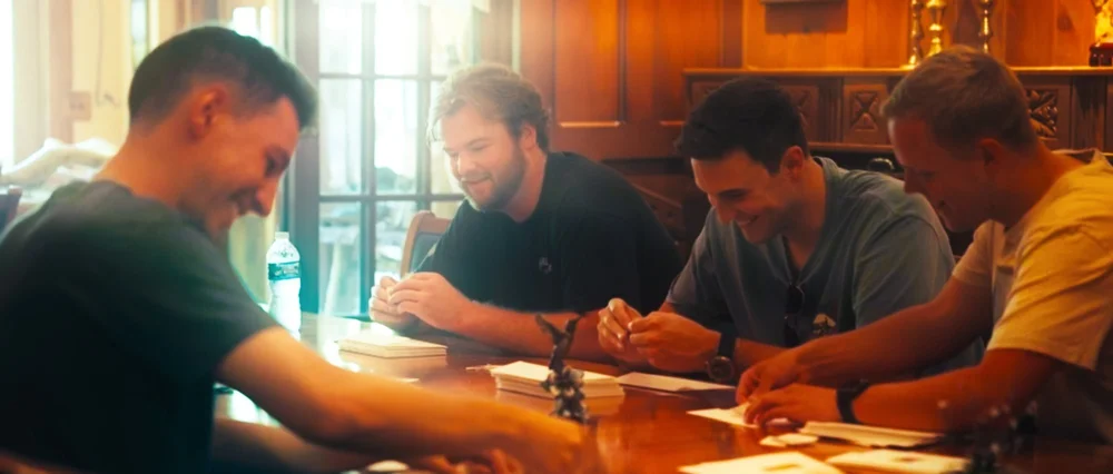 Brandon sitting at a table with friends during wedding preparations.