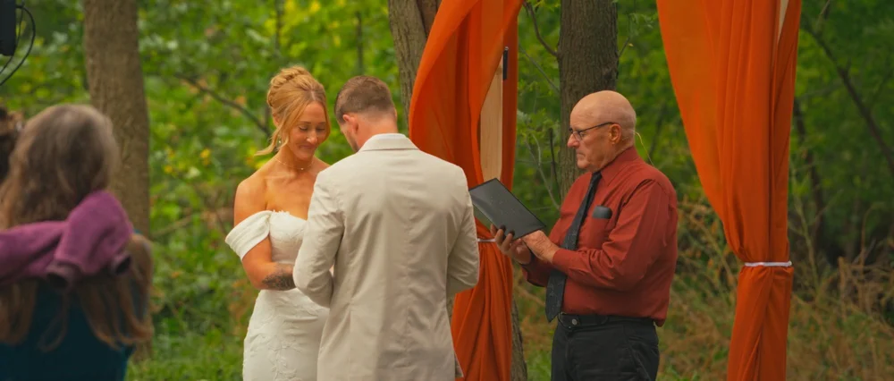 Abby and Daniel facing each other beneath the ceremony draping.