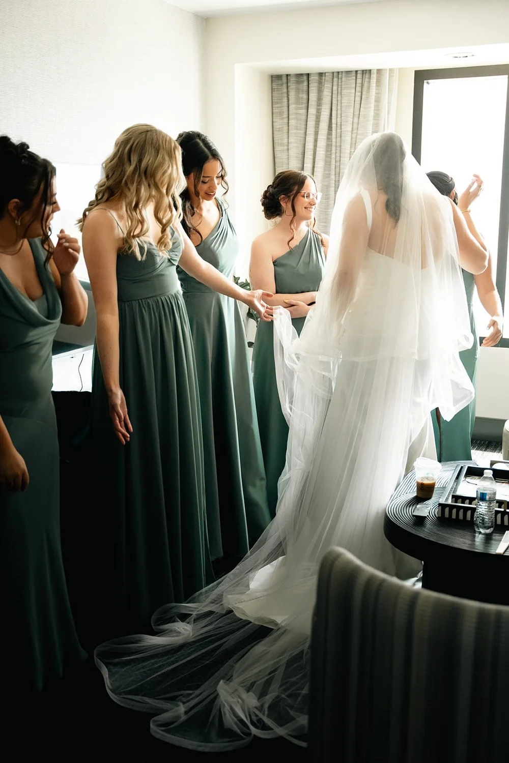 Grace's bridesmaids smile during their first look in the Hilton Omaha bridal suite