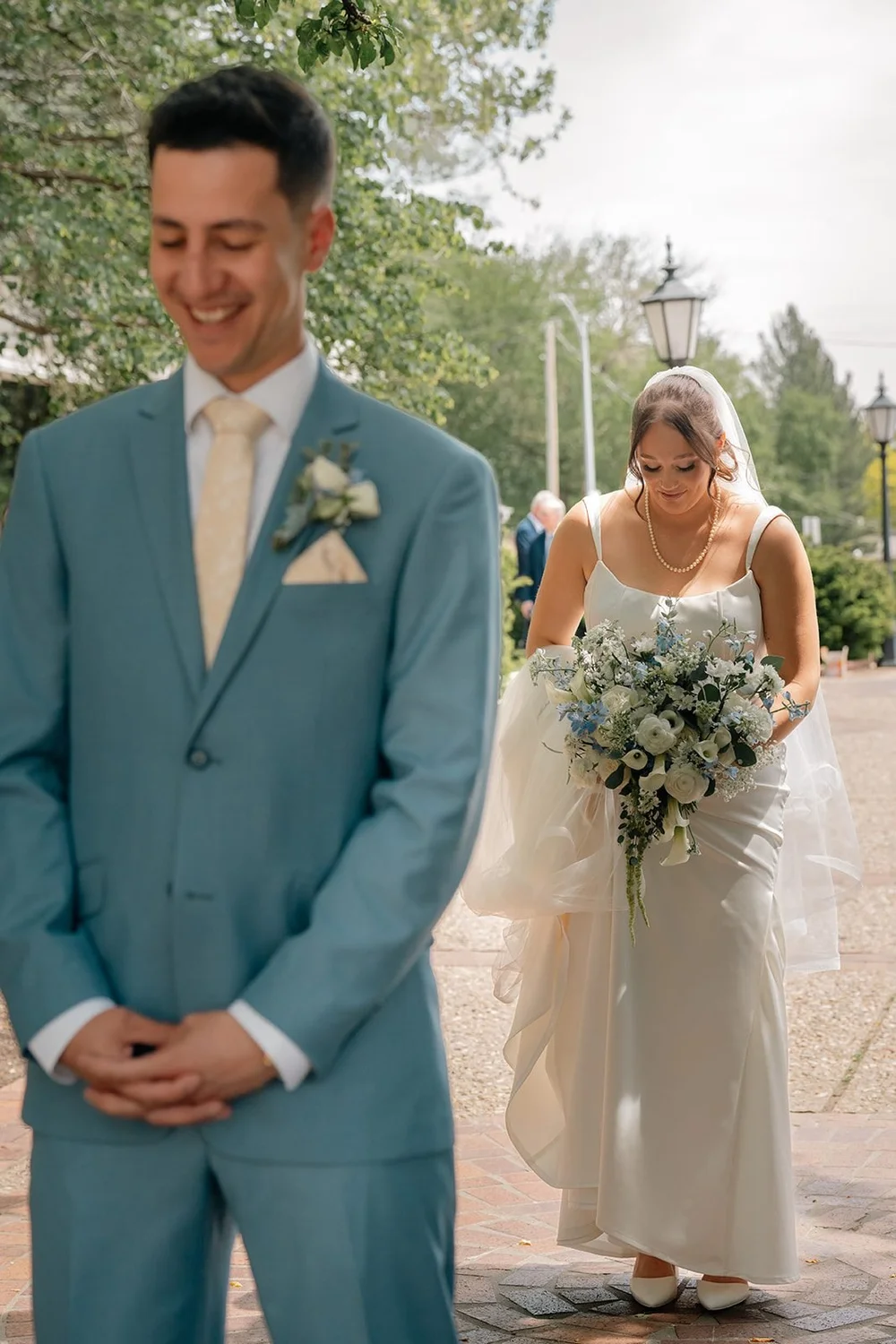 Grace walks through the Ford Birthsite gardens toward Alex for their first look
