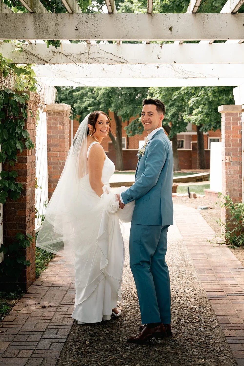 Grace and Alex stand beneath the white pergola at the Gerald R. Ford Birthsite