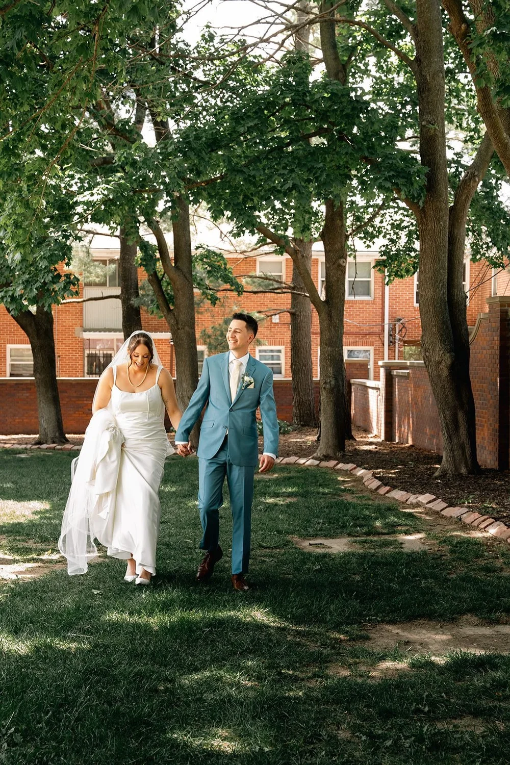 Grace and Alex walking together beneath the trees at the Gerald R. Ford Birthsite in Omaha.