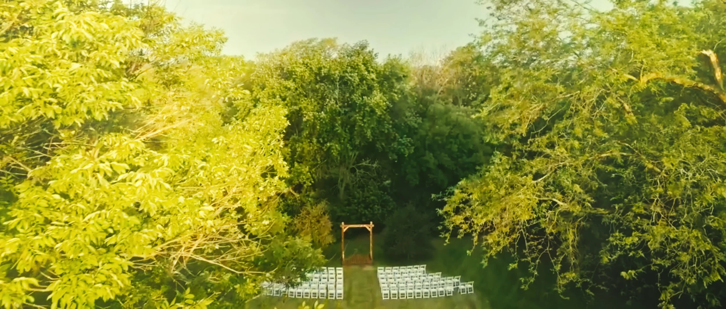 Aerial view of outdoor wedding ceremony aisle surrounded by trees in Lincoln Nebraska