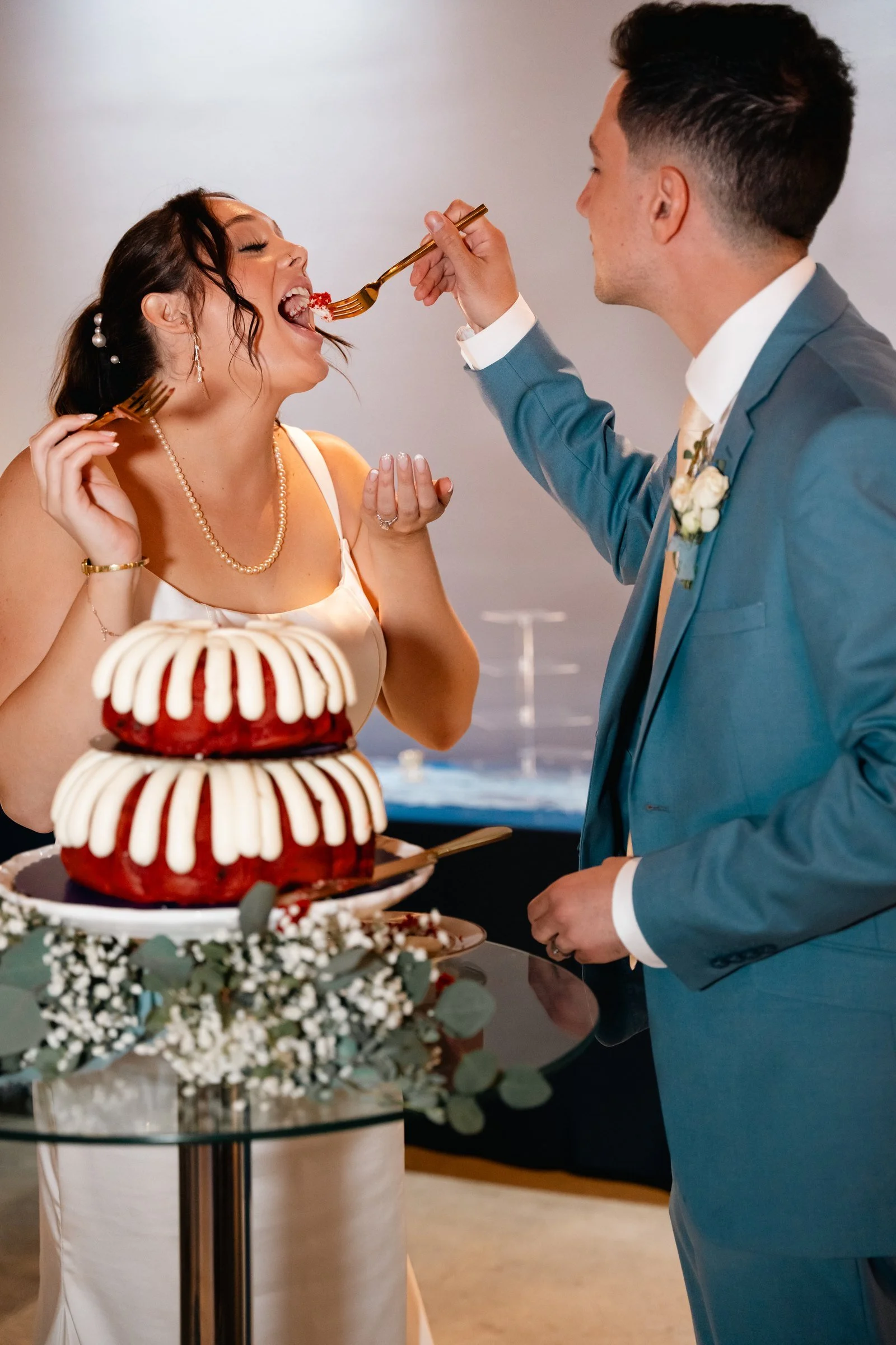Grace and Alex sharing cake at their Diamond Room wedding reception in Omaha.