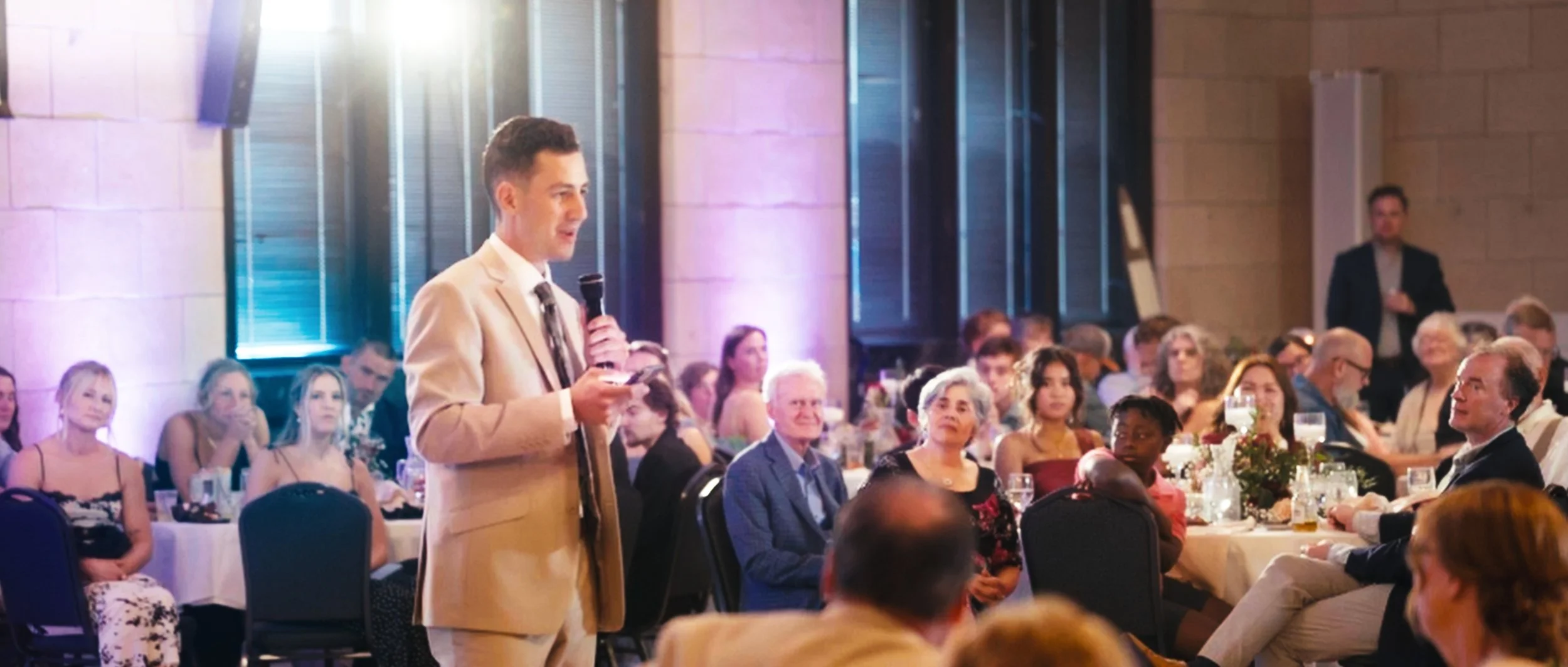 Wedding speech during reception at Lincoln Station Great Hall in Lincoln Nebraska with guests watching
