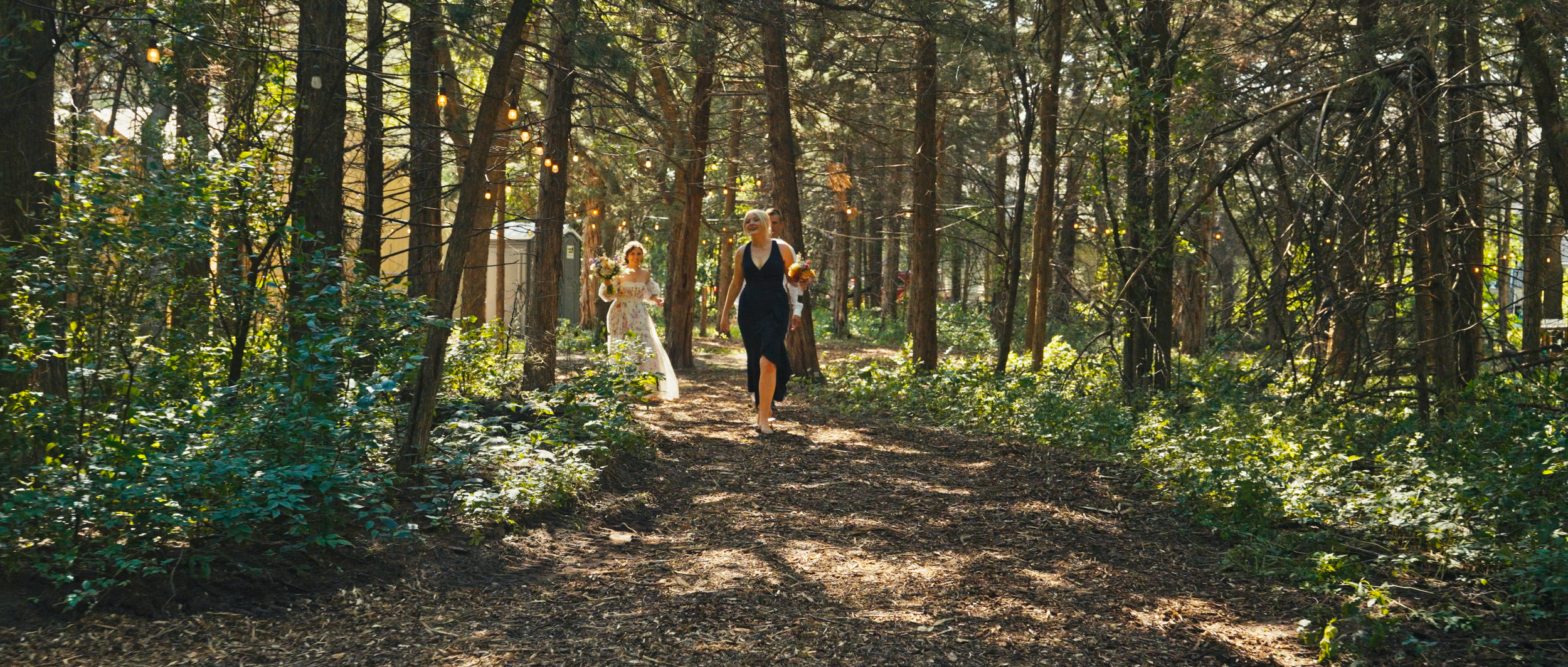 Forest Wedding Ceremony Entrance with String Lights in Nebraska