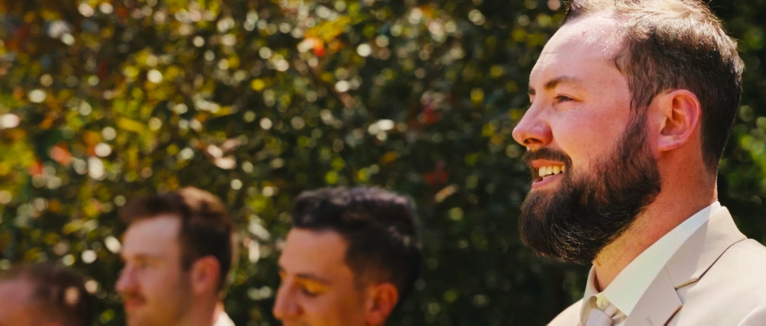 Groom smiling during outdoor wedding ceremony at family home in Lincoln Nebraska