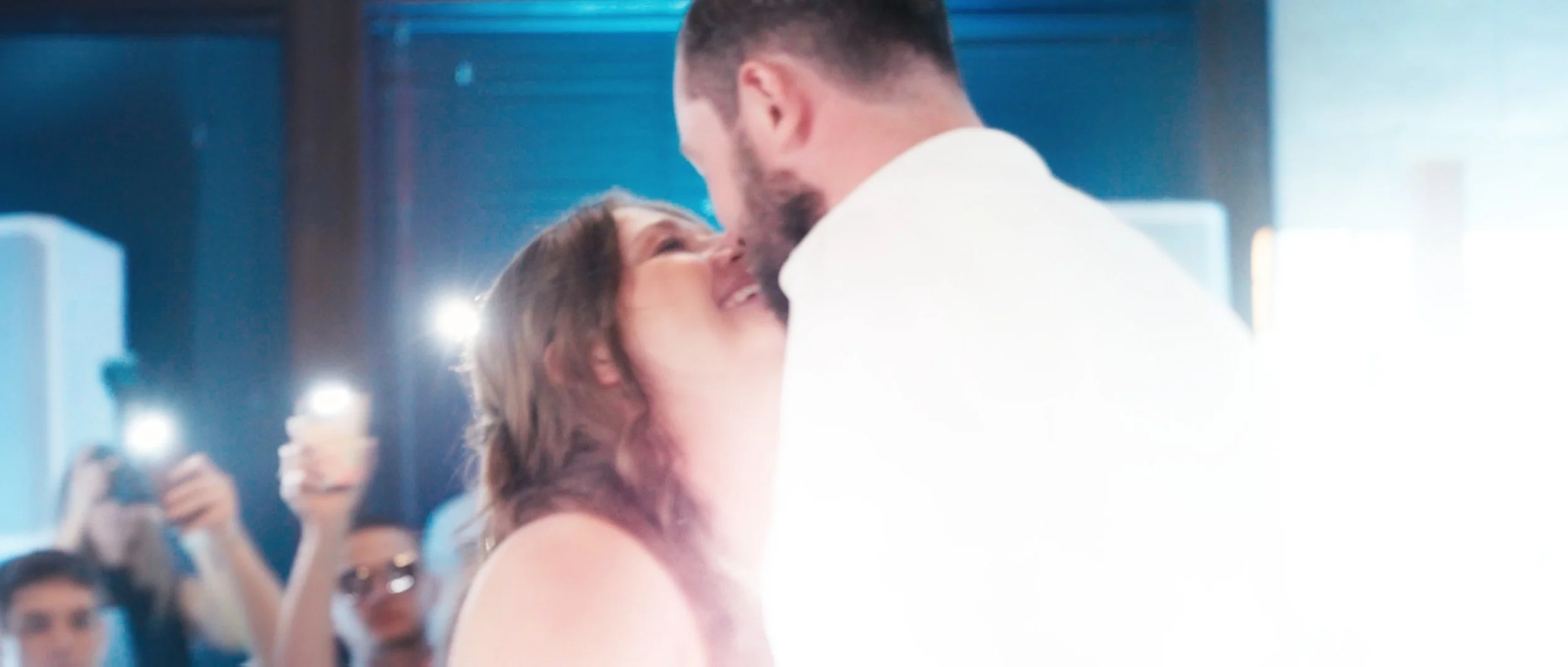 Bride and groom sharing a kiss during wedding reception at Lincoln Station Great Hall in Lincoln Nebraska