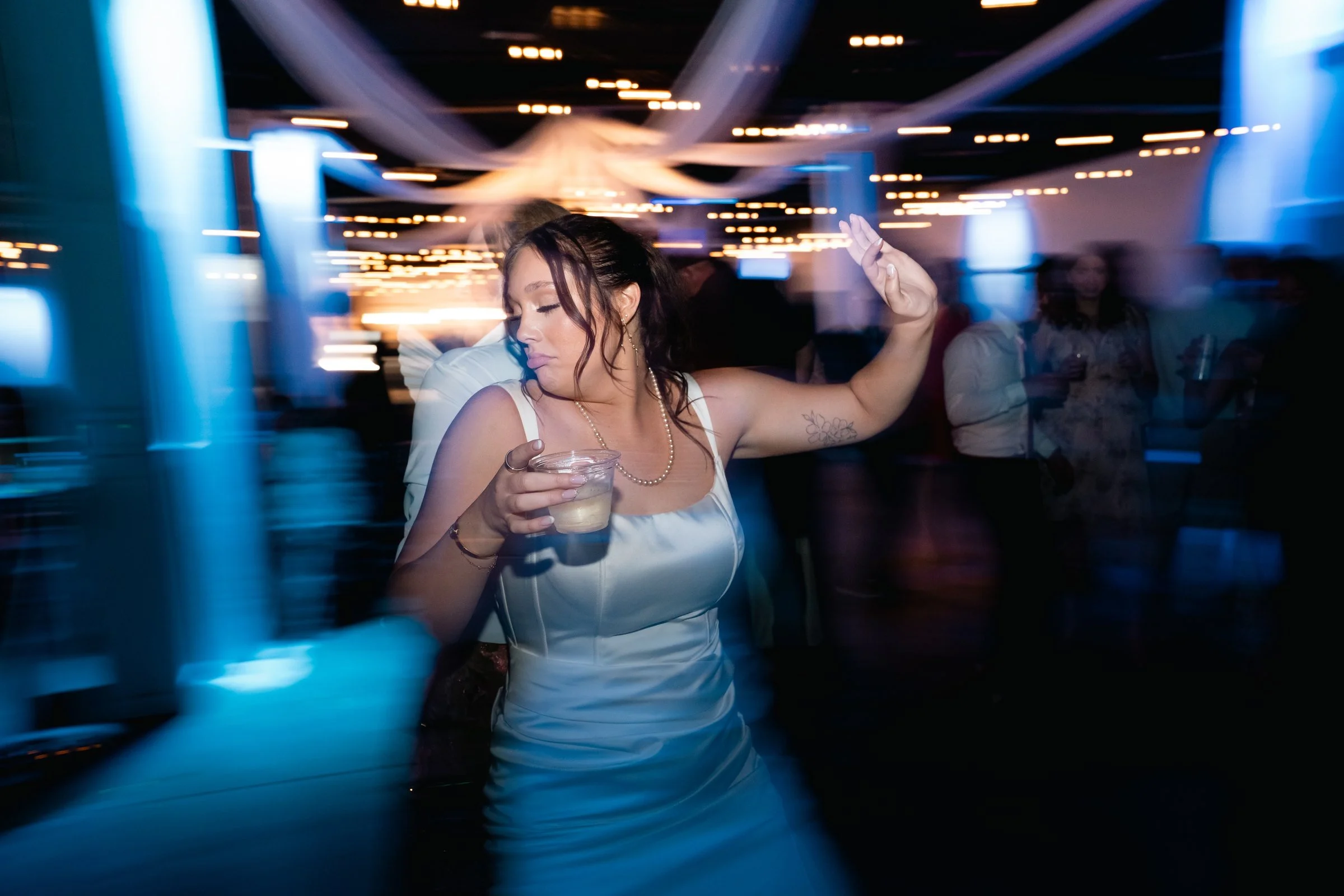Grace dancing beneath blue reception lights at the Diamond Room in Omaha.