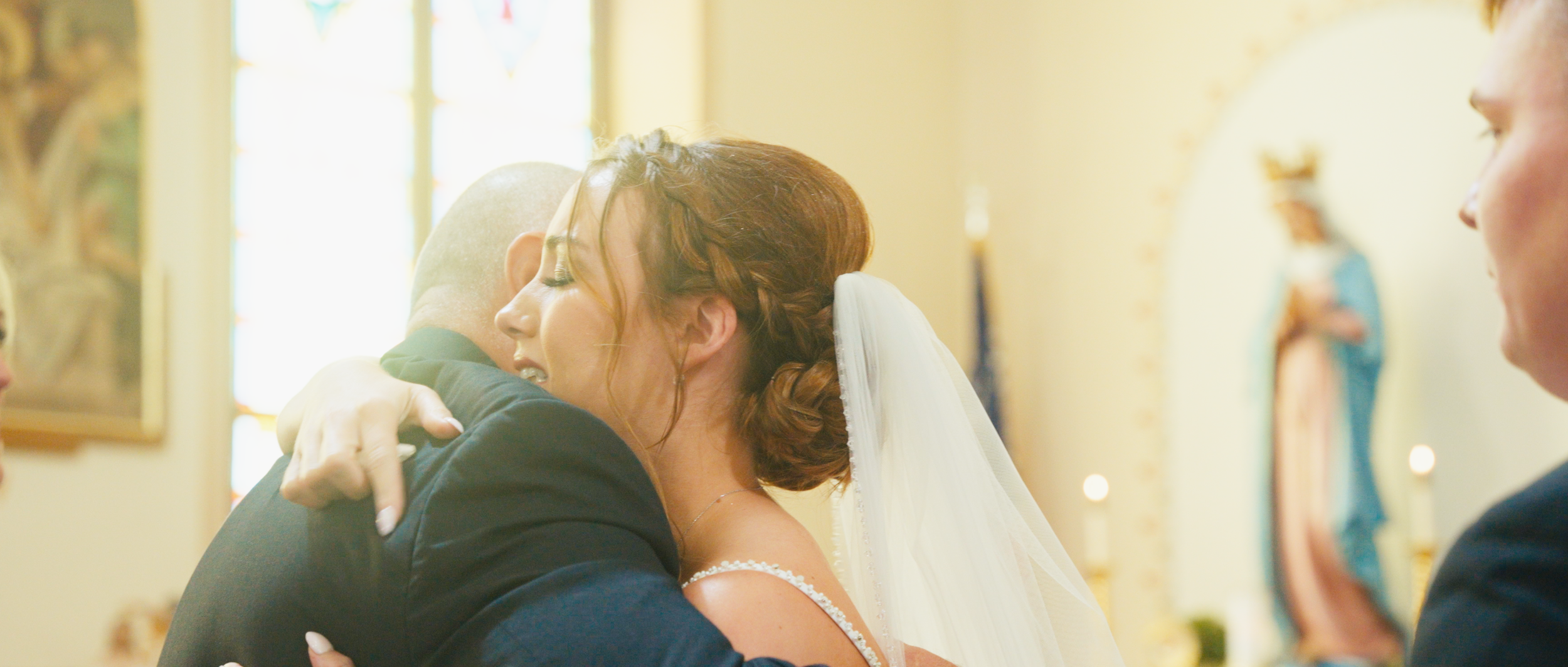 Bride embracing a family member after her wedding ceremony at St. Mary’s in Osmond, Nebraska