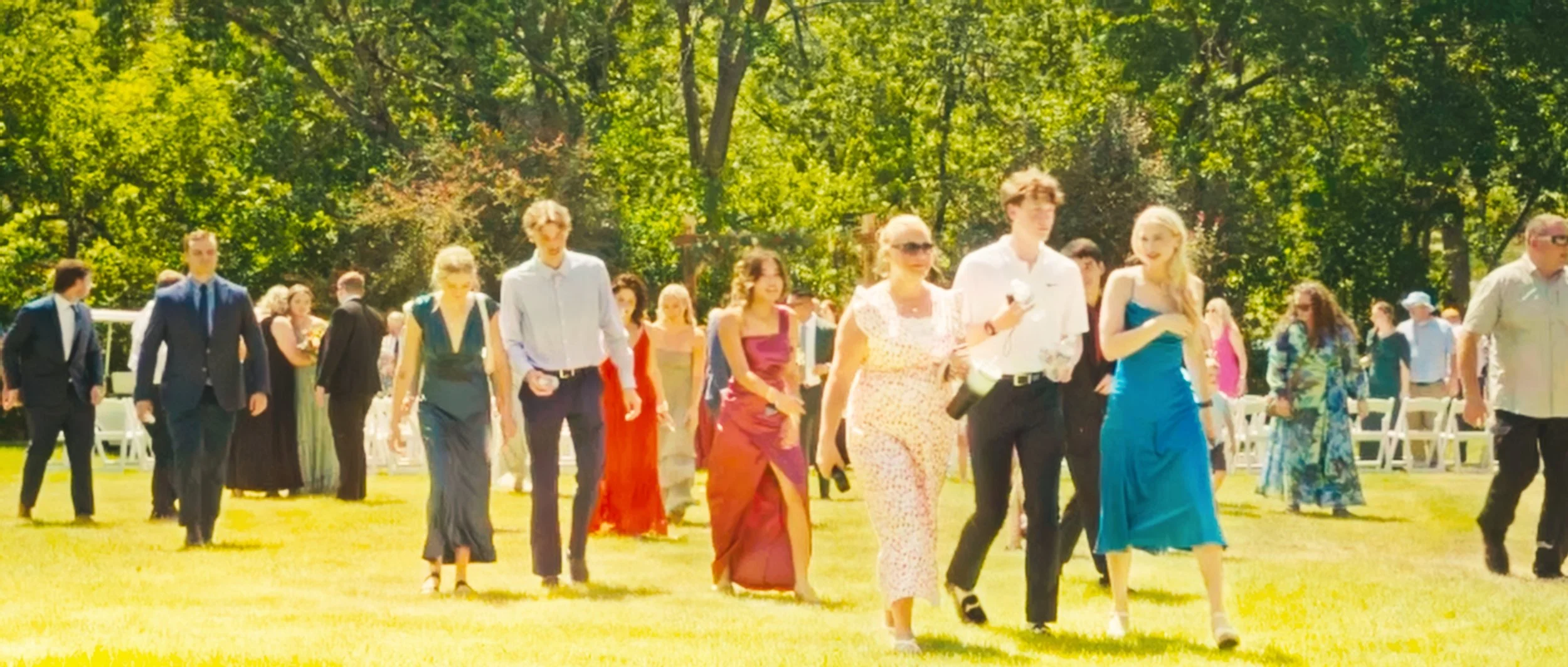 Wedding guests walking across lawn after backyard ceremony in Lincoln Nebraska