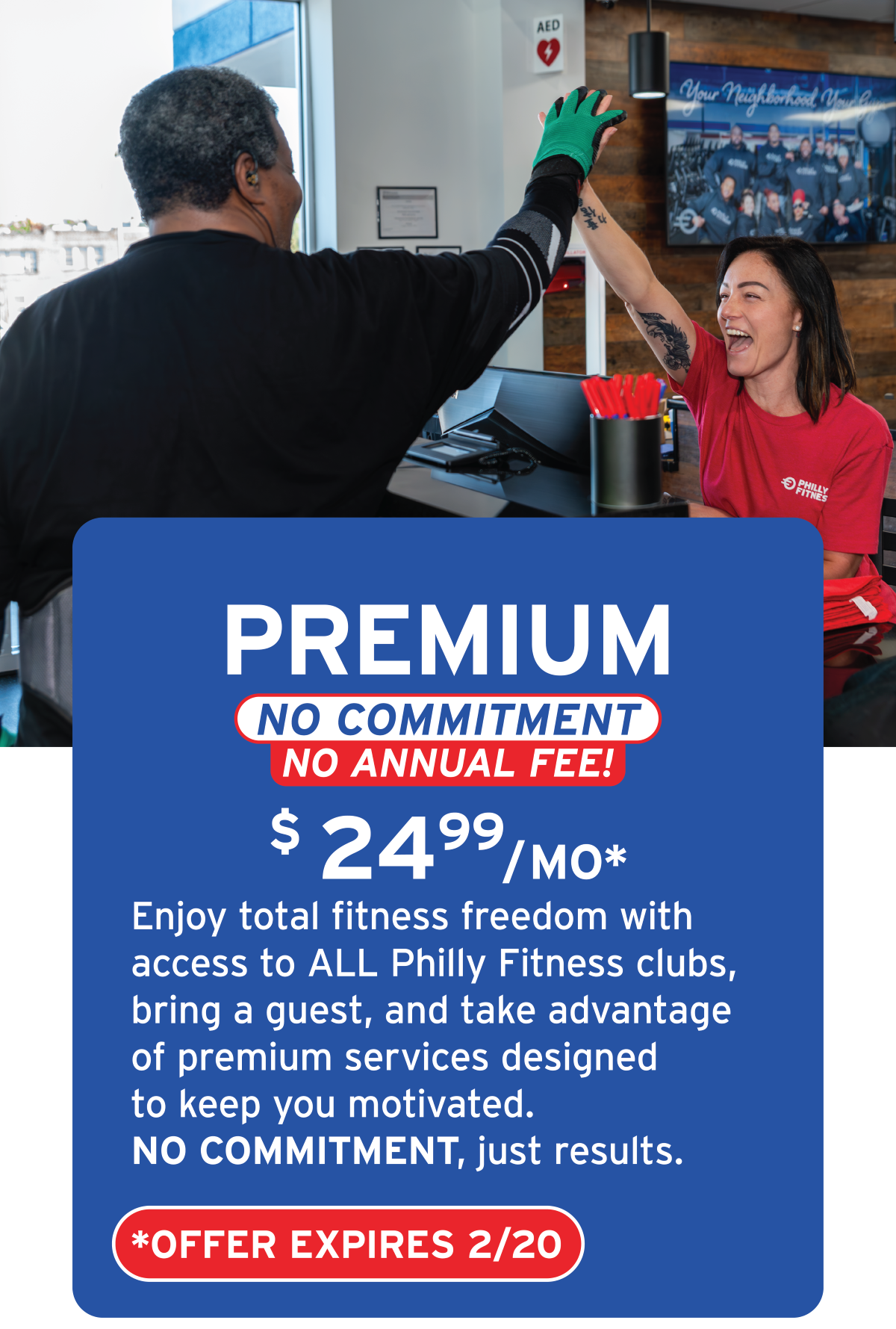 A woman and a man high-fiving at a fitness club reception area. The woman is wearing a red shirt with 'Philly Fitness' and the man is in black athletic clothing. There is a blue promotional sign in the foreground offering a gym membership for $24.99/month with no commitment or annual fee.