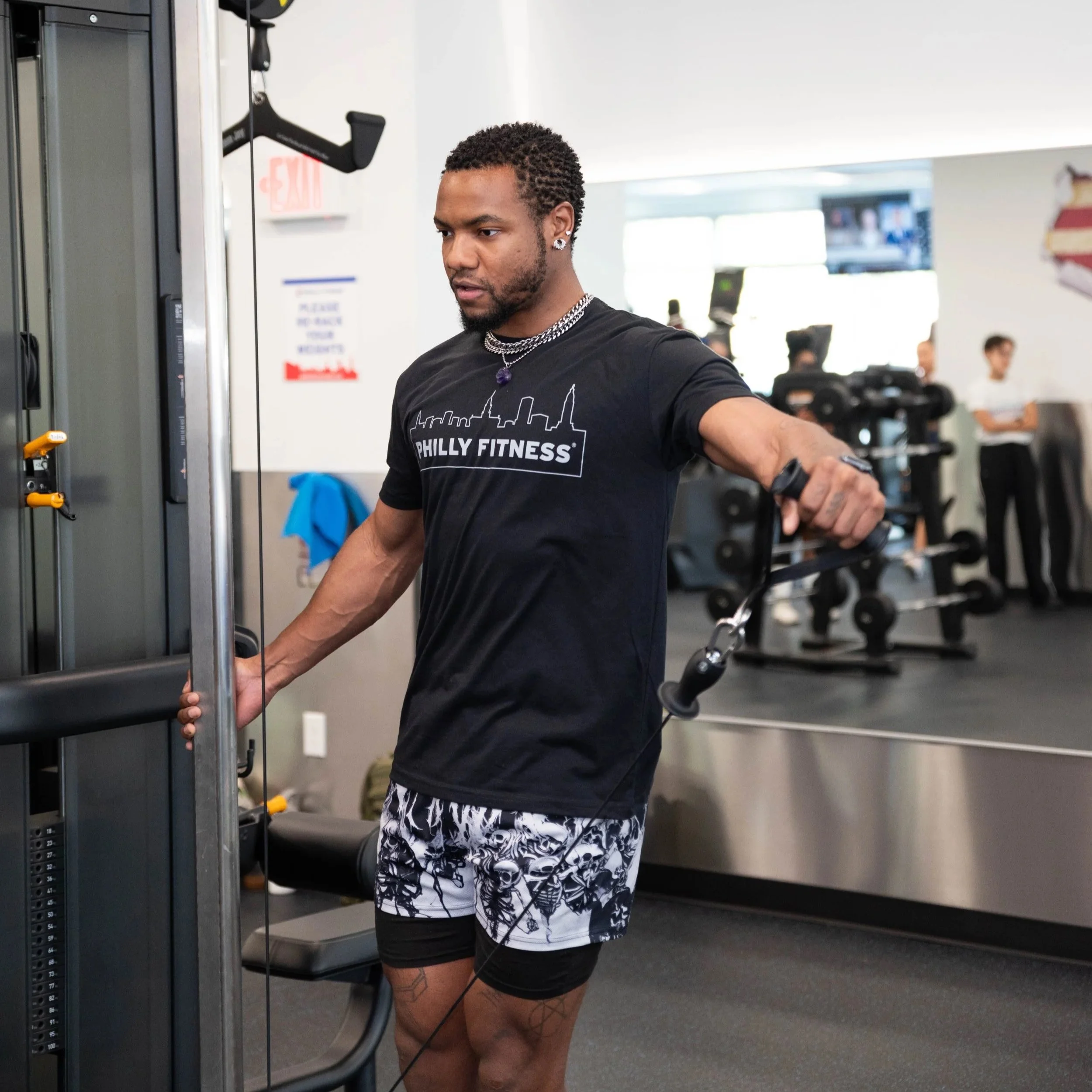Gym member on the weight cables in a Philly Fitness® Balck Skyline T-Shirt