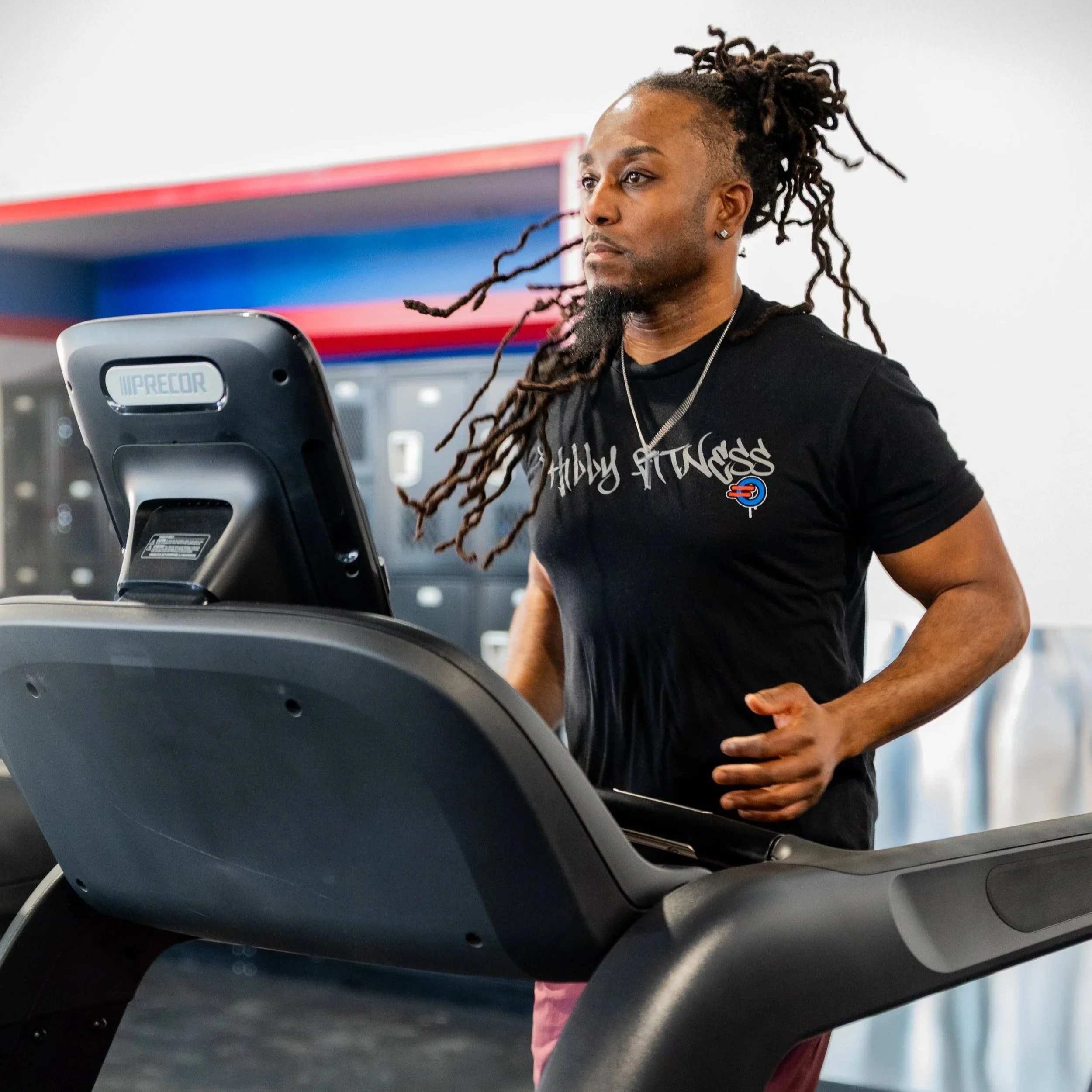 Gym member running on the treadmill while wearing their Philly Fitness® Black Graffiti Street Sign T-Shirt