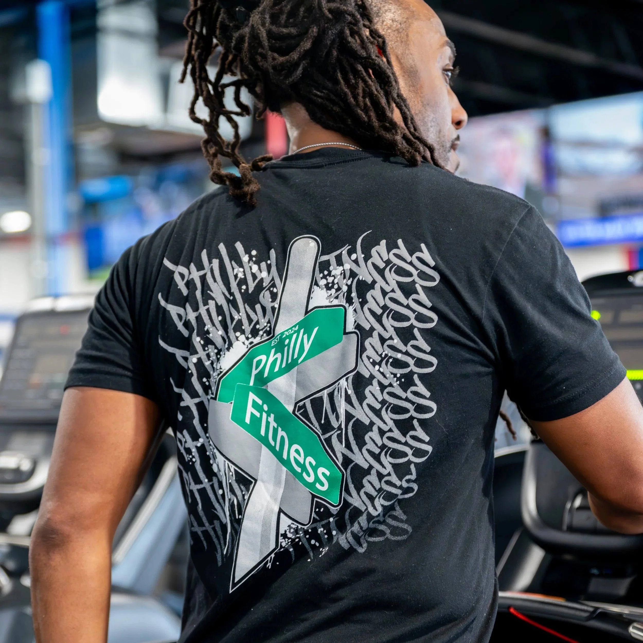 Gym member walking the treadmill in their Philly Fitness® Black Graffiti Street Sign T-Shirt