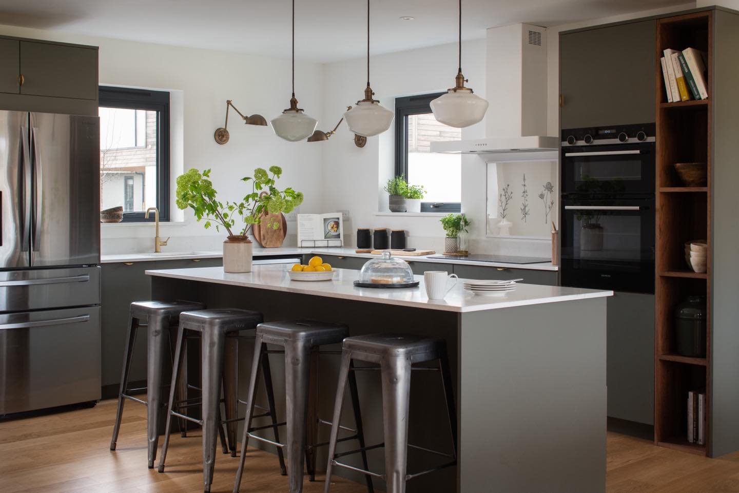 Hand made kitchen, designed for a modern country house in Dorset. The green works beautifully with the open walnut shelving and a veined white quartz worktop #greenkitchen #walnut #openshelving #bythecoast