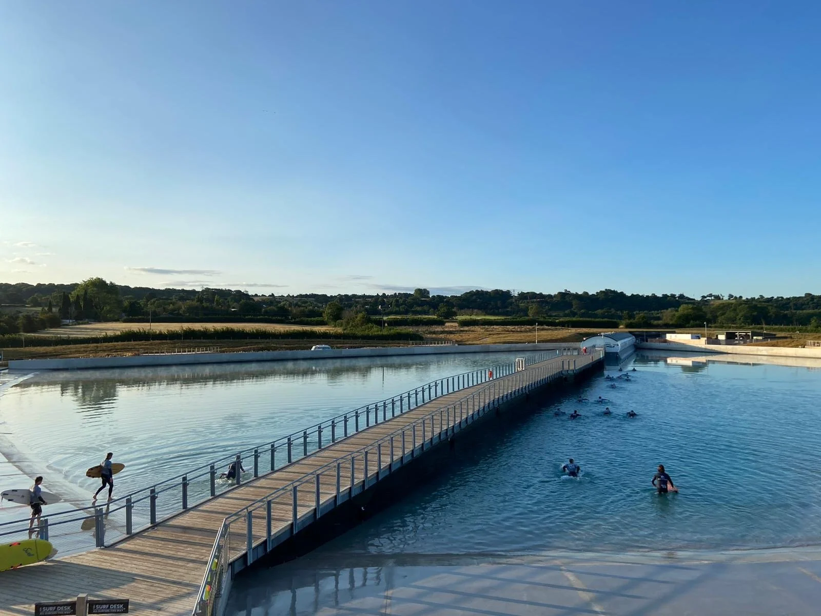 Surfers heading into the lake on a sunny day